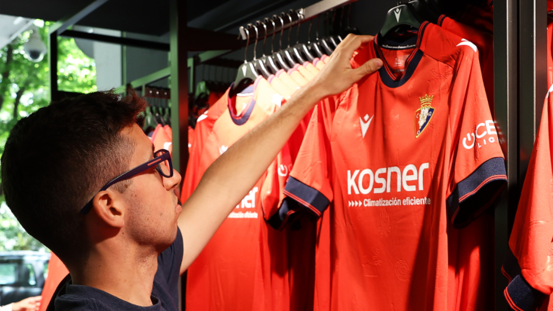 Un aficionado ojea la nueva camiseta de Osasuna, en la tienda de El Sadar