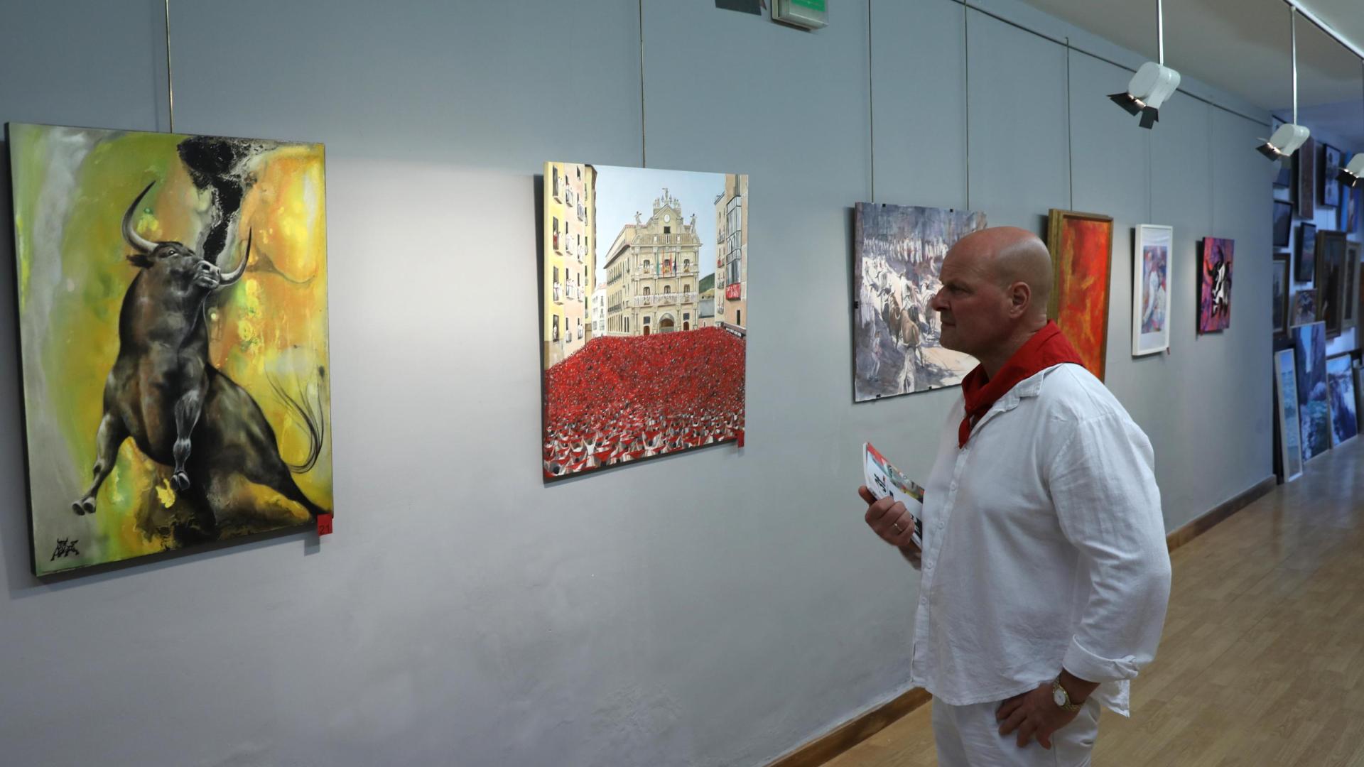 Michel Menéndez contempla algunas de las obras que cuelgan en su galería.