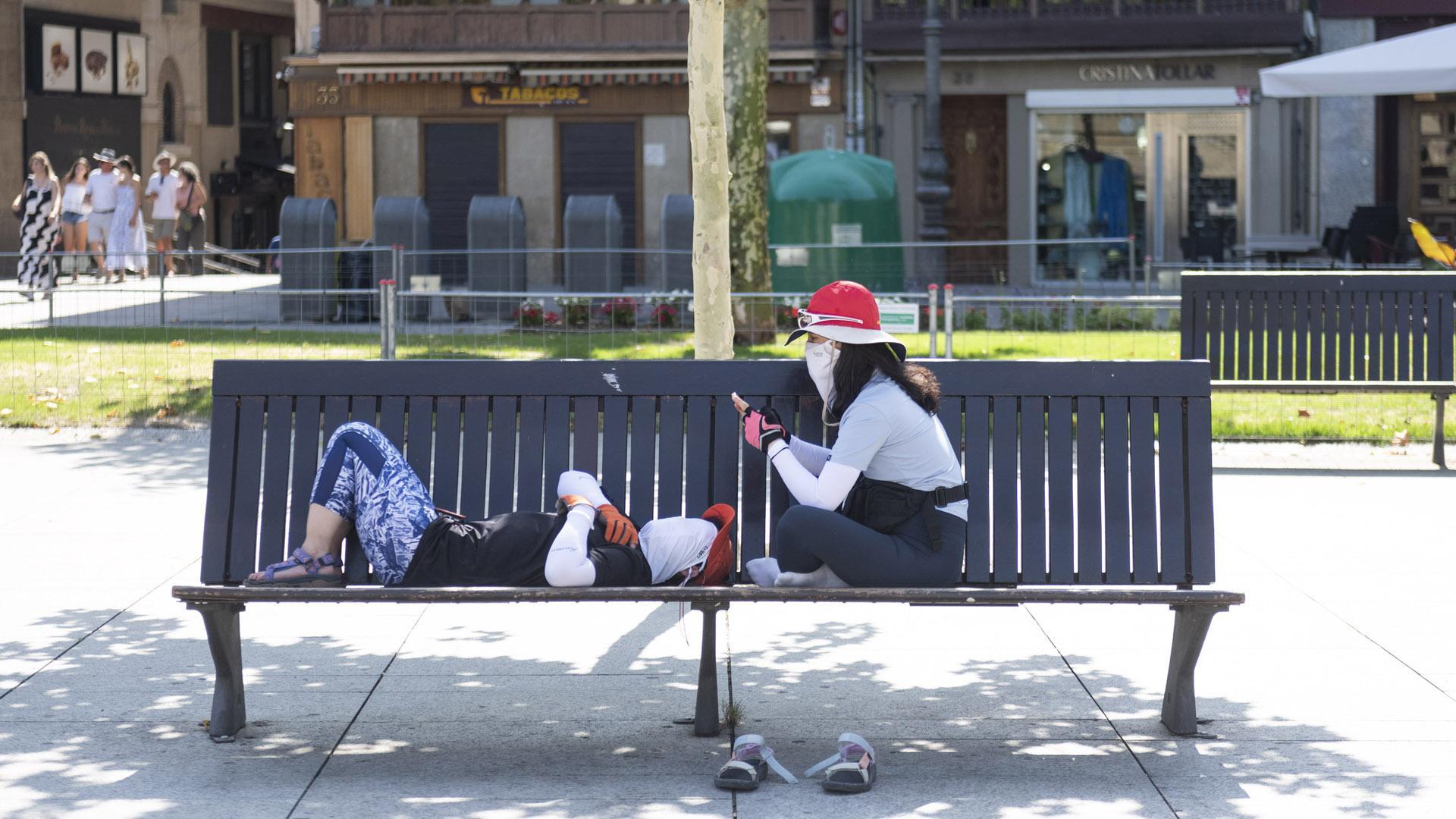 Dos peregrinos descansando en uno de los bancos de la Plaza del Castillo durante la tarde de este miércoles