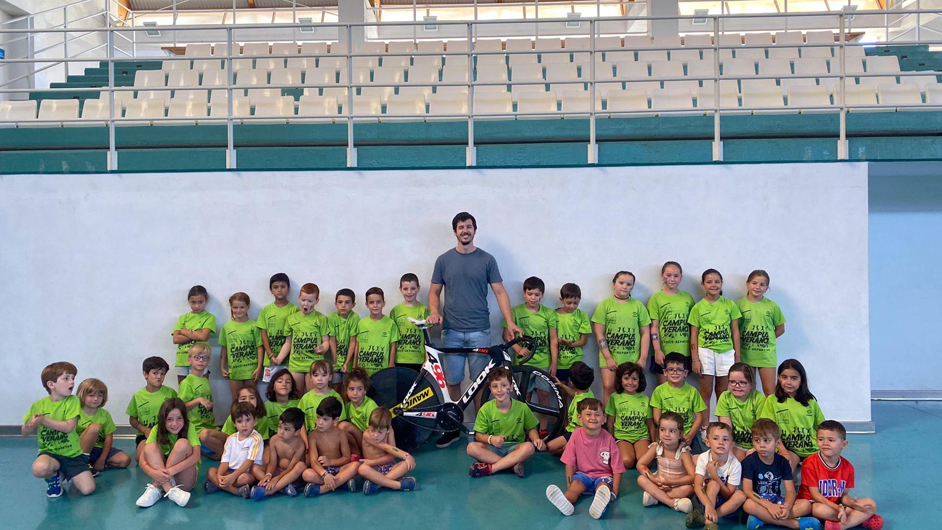 Varios de los niños participantes en la Semana Olímpica de Cintruénigo, junto al ciclista cirbonero Sergio Aliaga y una de sus bicicletas de competición