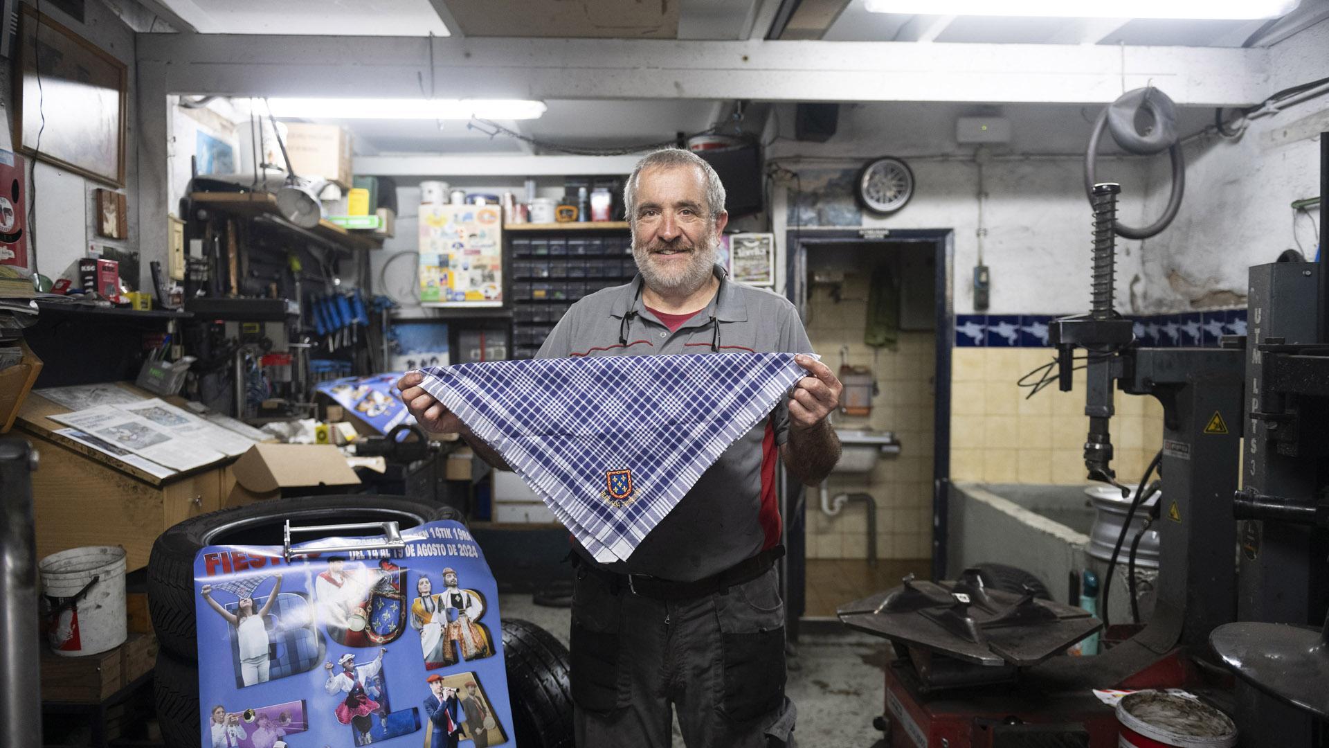 Félix de Miguel posa con un pañuelo y el cartel de fiestas