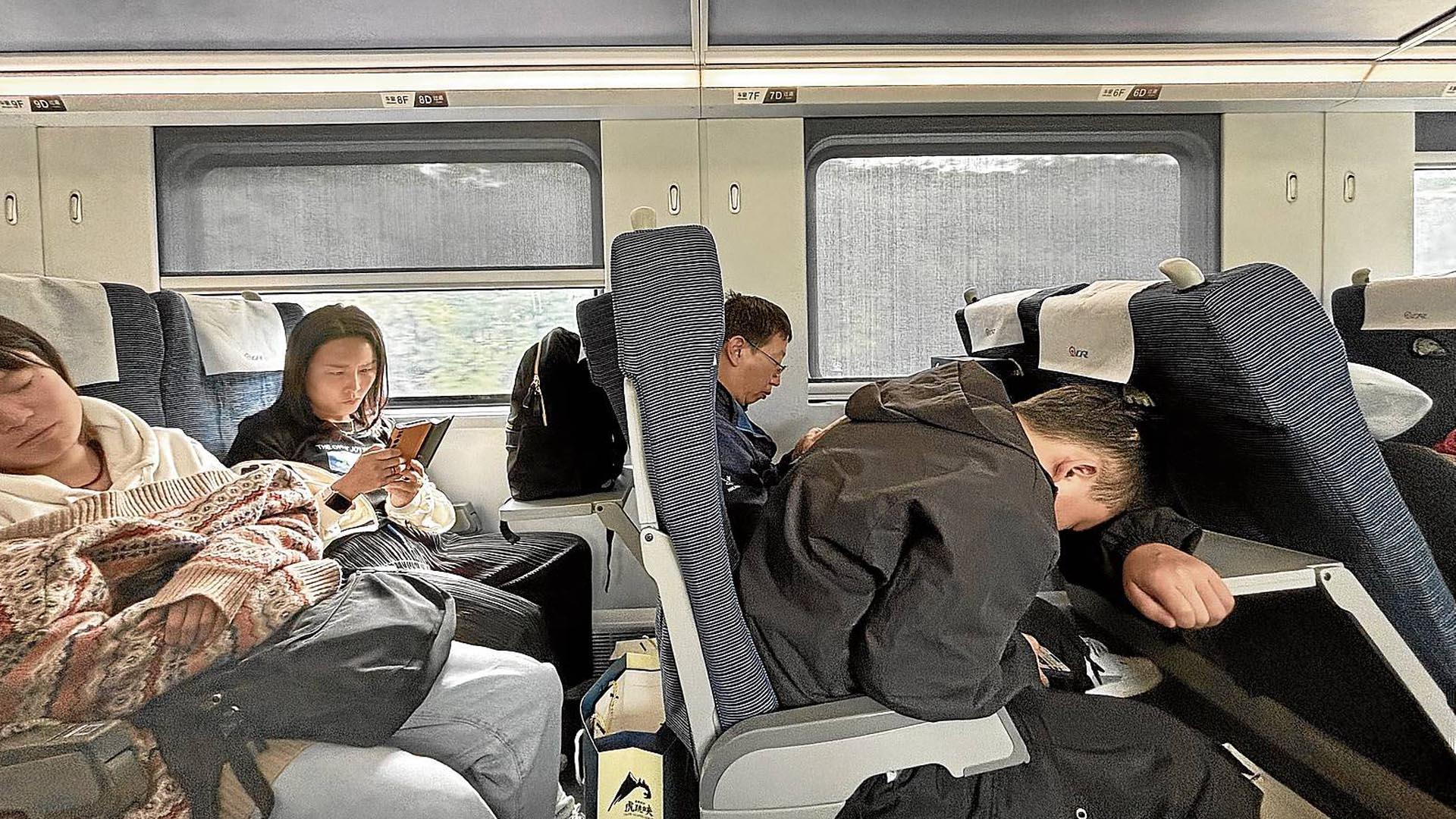 Pasajeros en tren bala hacia Kunming. Algunos aprovechan el trayecto para leer o dormir en posiciones imposibles