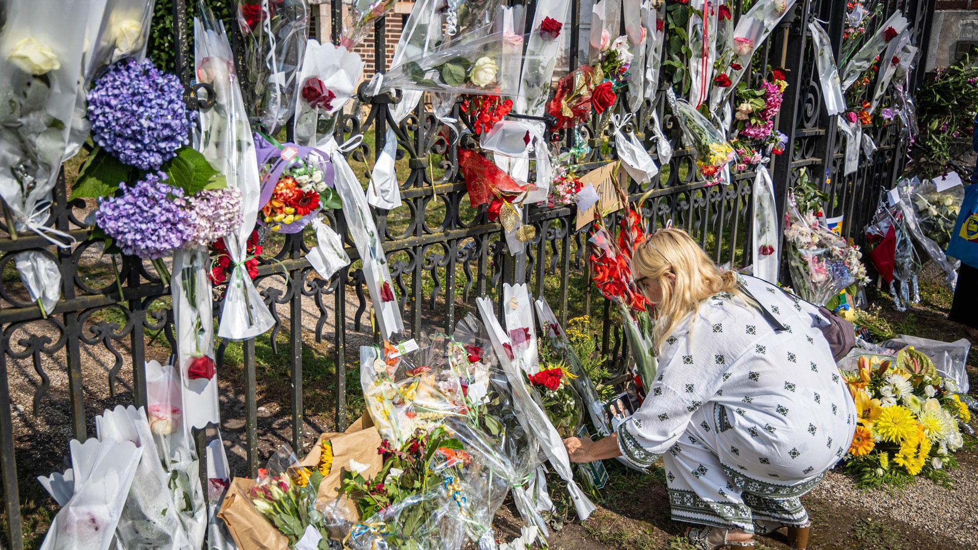 La gente se acerca a deposita flores, fotos y dibujos para rendir homenaje al fallecido actor francés Alain Delon frente a su propiedad en Douchy, Francia