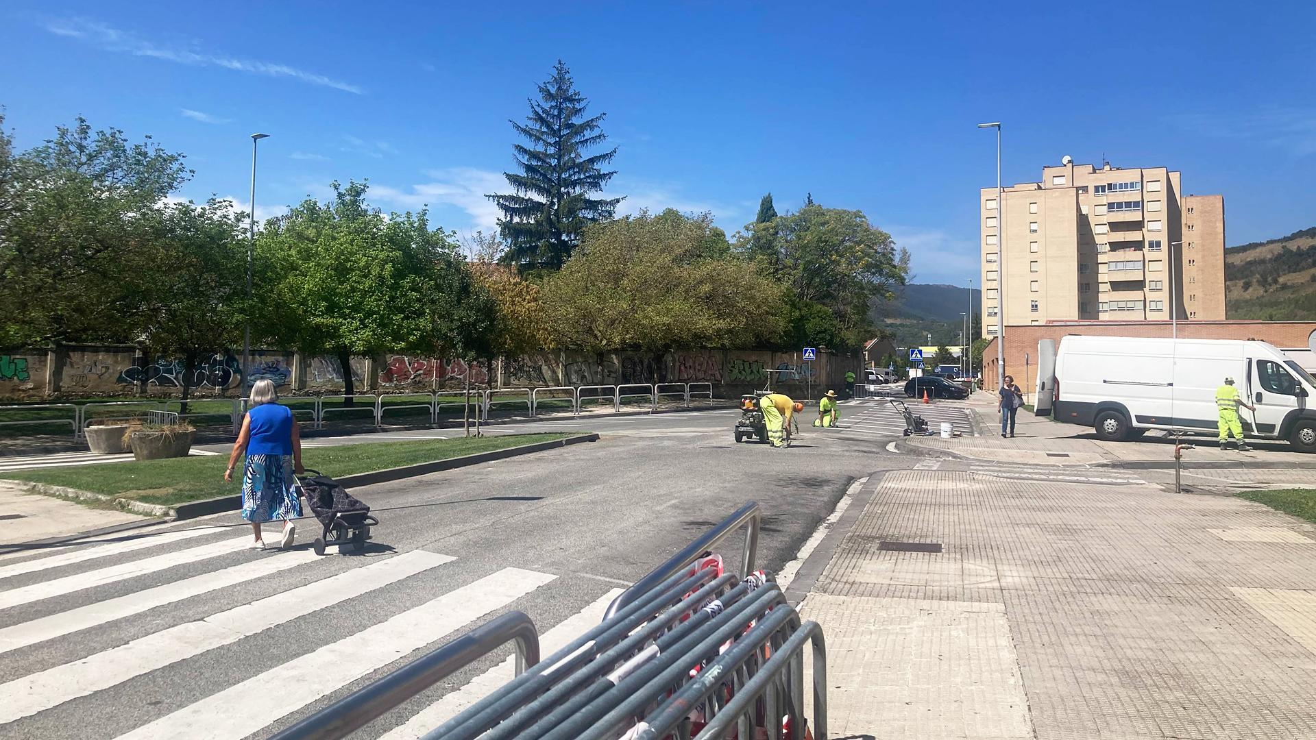 Una persona atraviesa el tramo cortado al tráfico en la calle Ezkaba mientras cambian la señalización