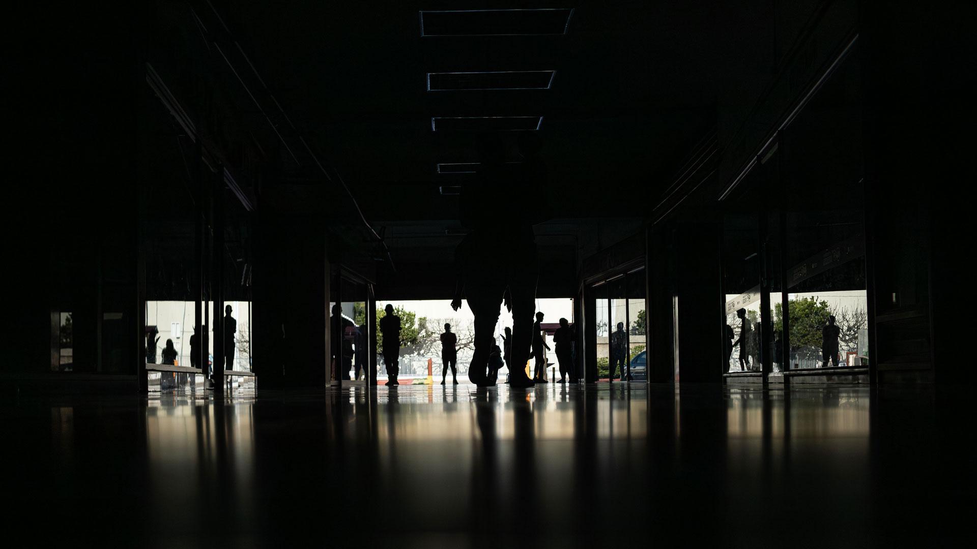 Personas caminan por el Centro comercial Ciudad Chinita con la mayoría de sus locales cerrados por falta de electricidad en Venezuela