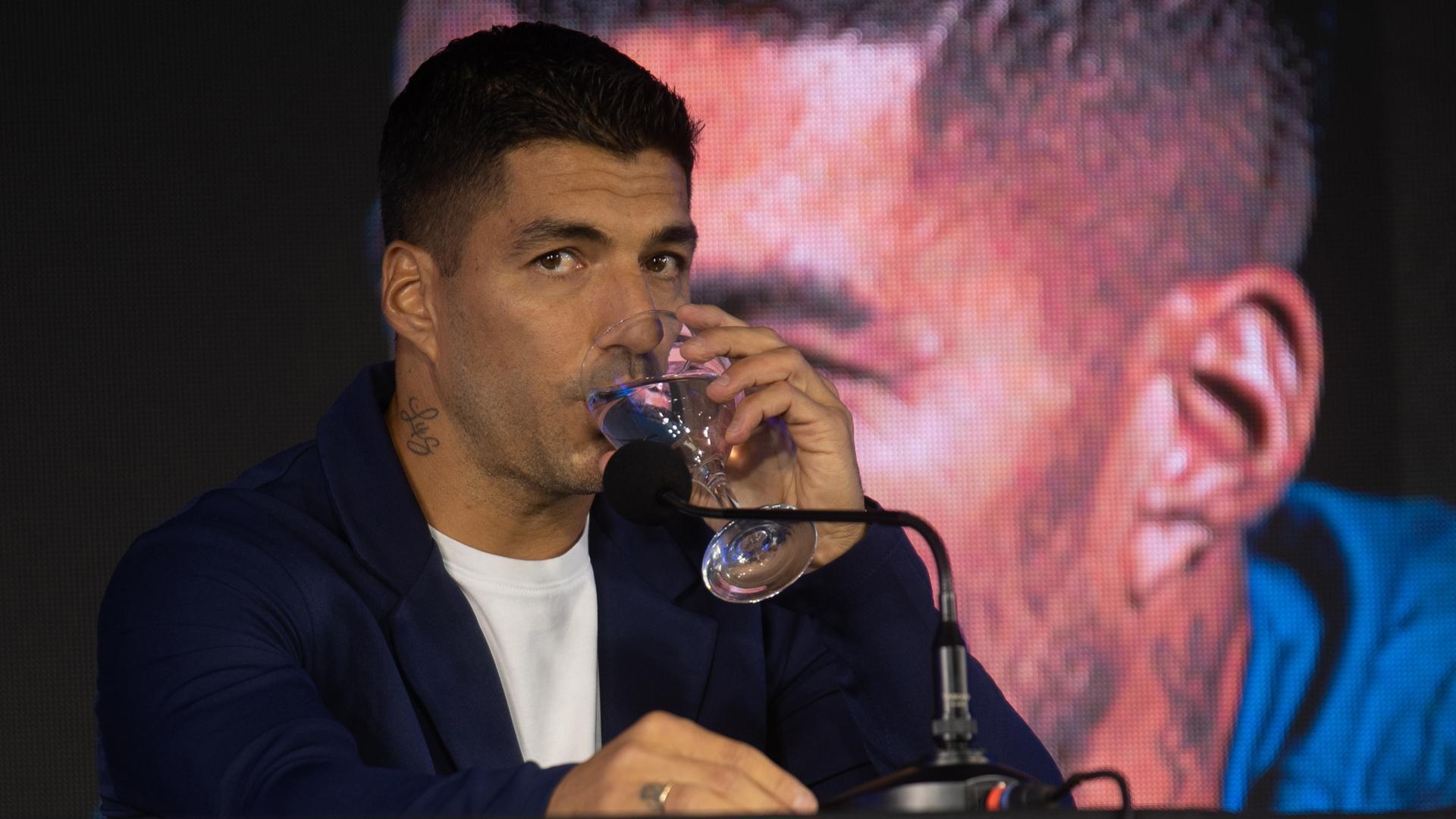 El futbolista uruguayo Luis Suárez toma agua durante una rueda de prensa este lunes en Montevideo (Uruguay)