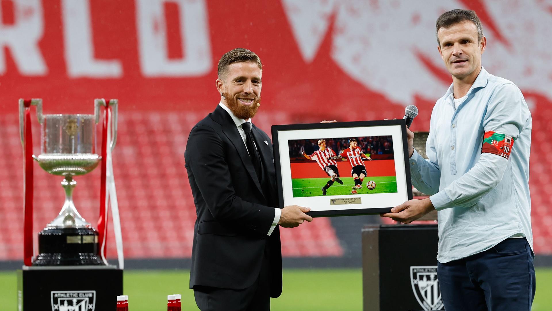 El jugador del Athletic Club, Iker Muniain (i) acompañado por el presidente del equipo bilbaino, Jon Uriarte, en un momento del homenaje