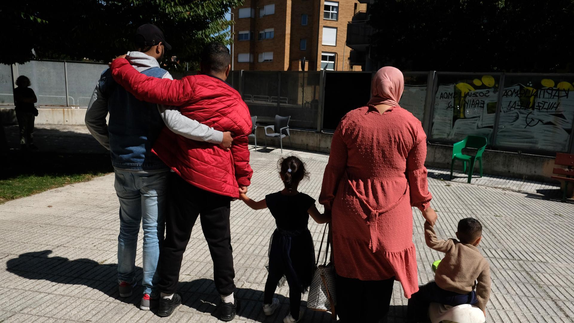 Youssef, agarrado por el traductor para que no pierda el equilibrio, junto a Ilham y sus dos hijos pequeños, de 4 y 3 años