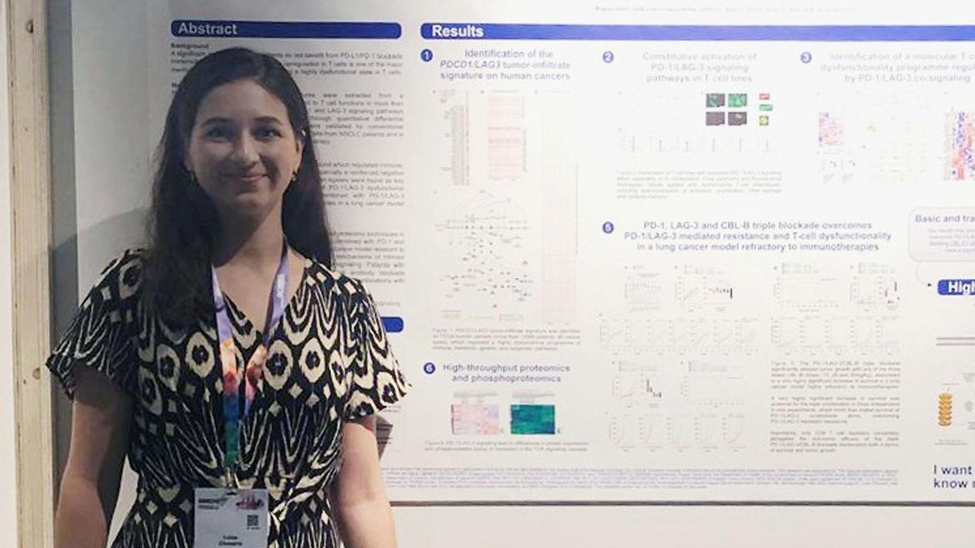 Luisa Chocarro, delante del póster premiado en el congreso de la Sociedad Europea de Oncología Médica (ESMO)