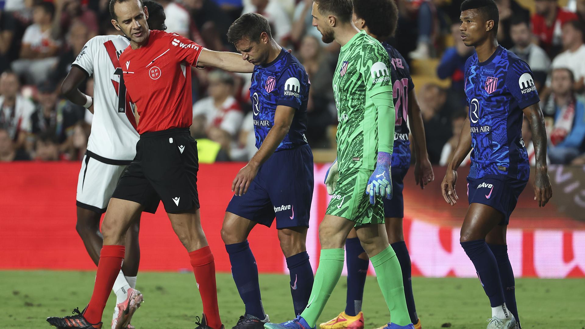 César Azpilicueta, acompañado por el colegiado y parte de sus compañeros, camina hacia el vestuario tras lesionarse en Vallecas