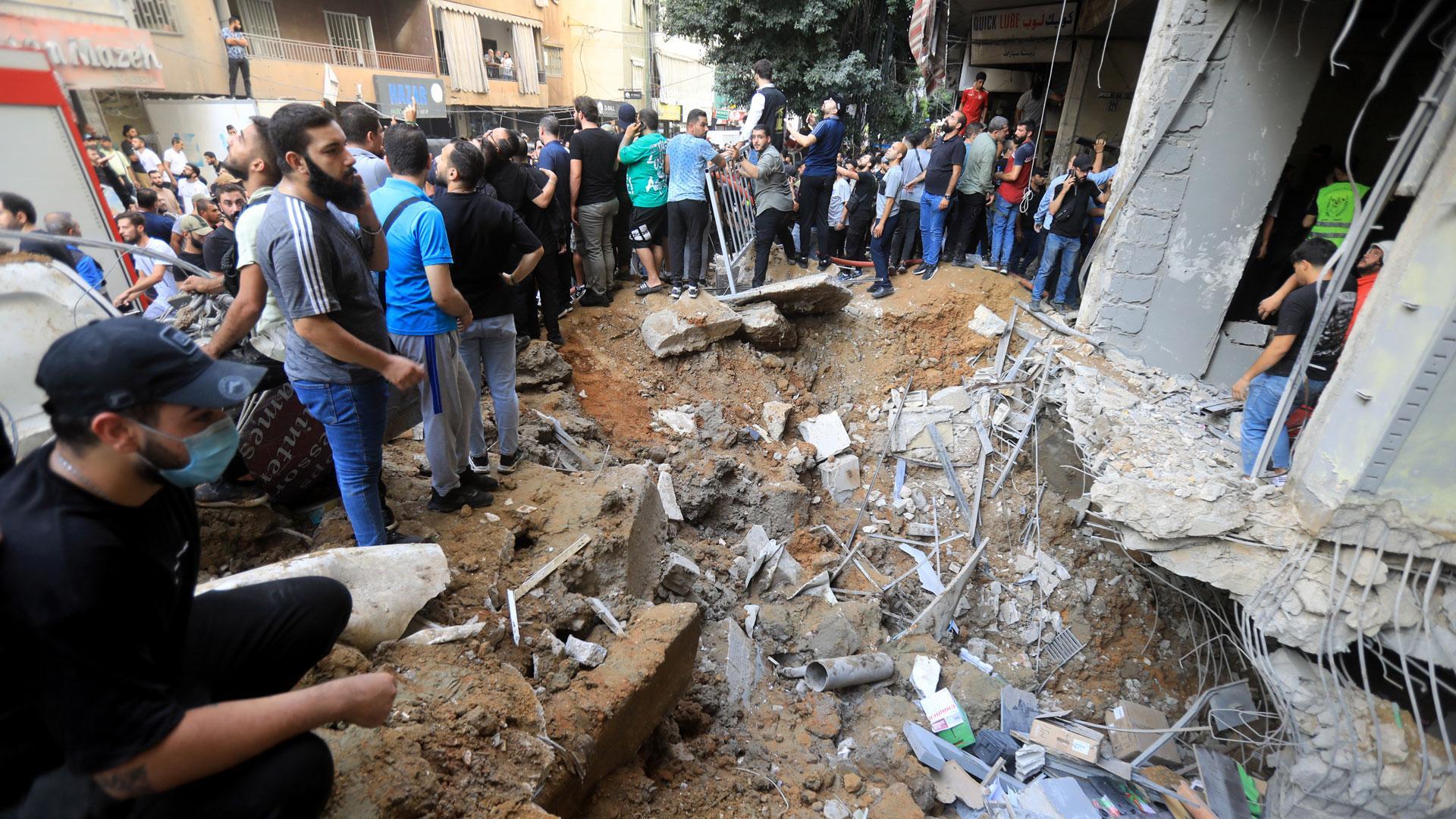 Un grupo de personas junto a un edificio bombardeado por el Ejército de Israel en Beirut