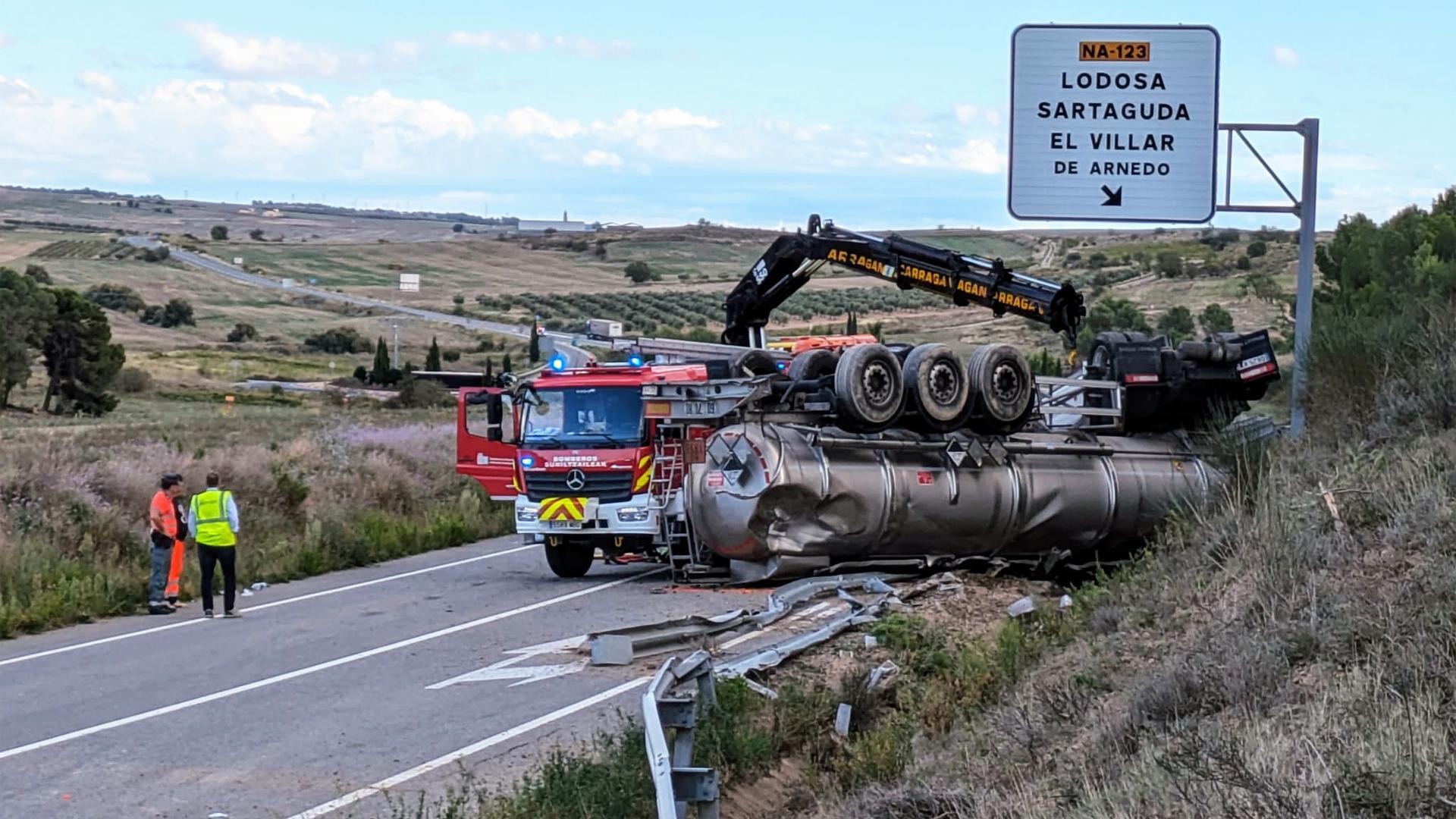 La grúa de los Bomberos de Navarra trabaja en la retirada del camión con ácido sulfúrico que volcó tras el accidente