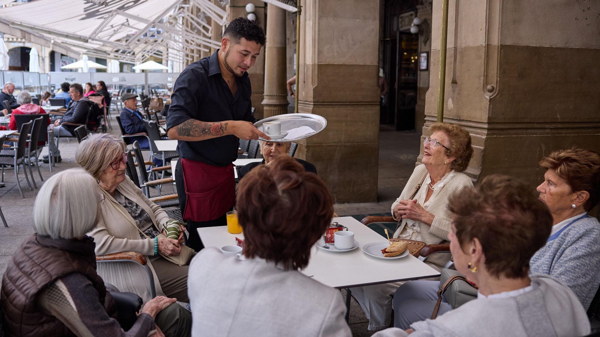 Un camerero le sirve a unas señoras en el Café Iruña