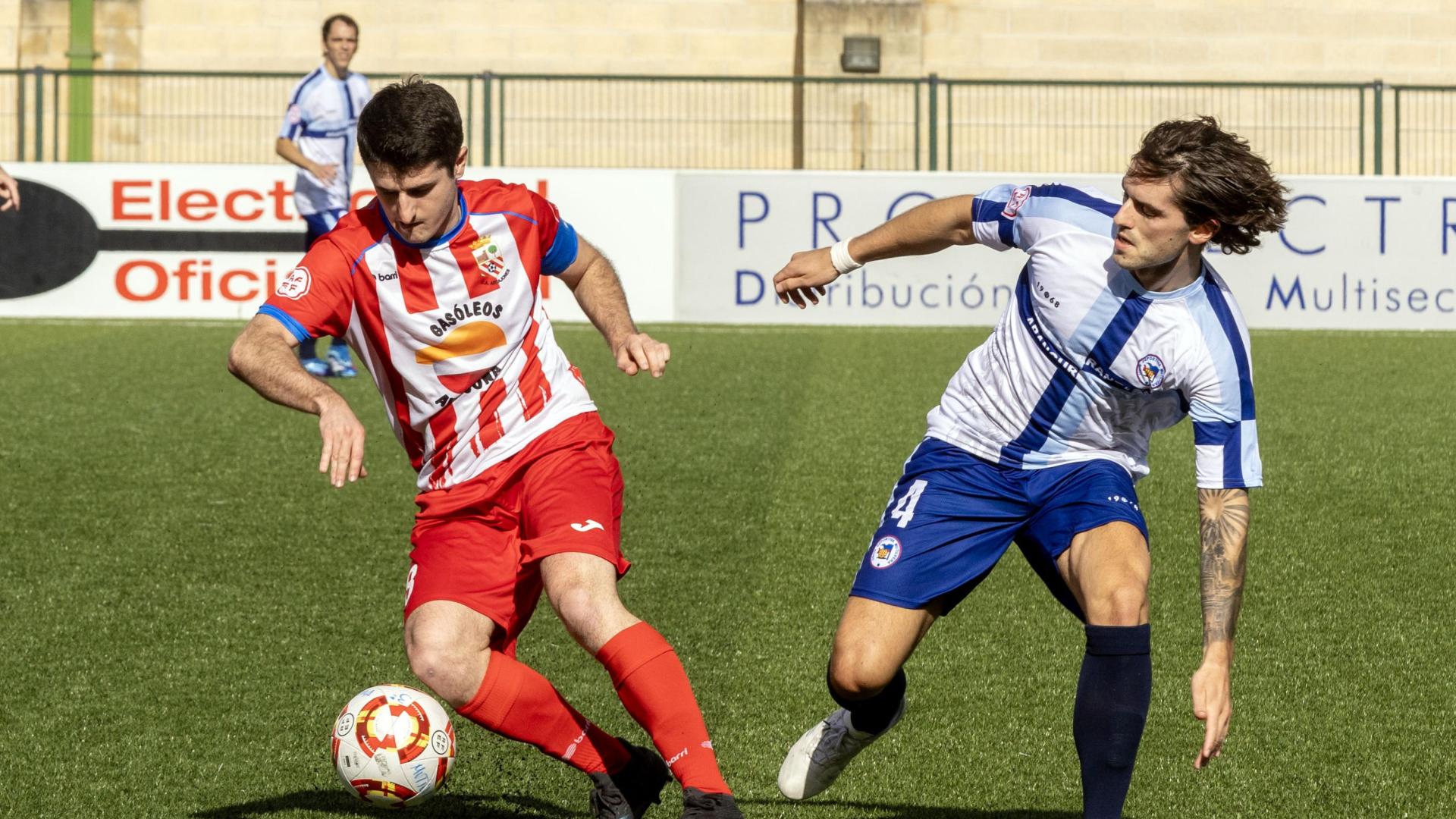Adrián Salinas, del Artajonés, controla el balón ante Carlos Soroa, de la Mutilvera