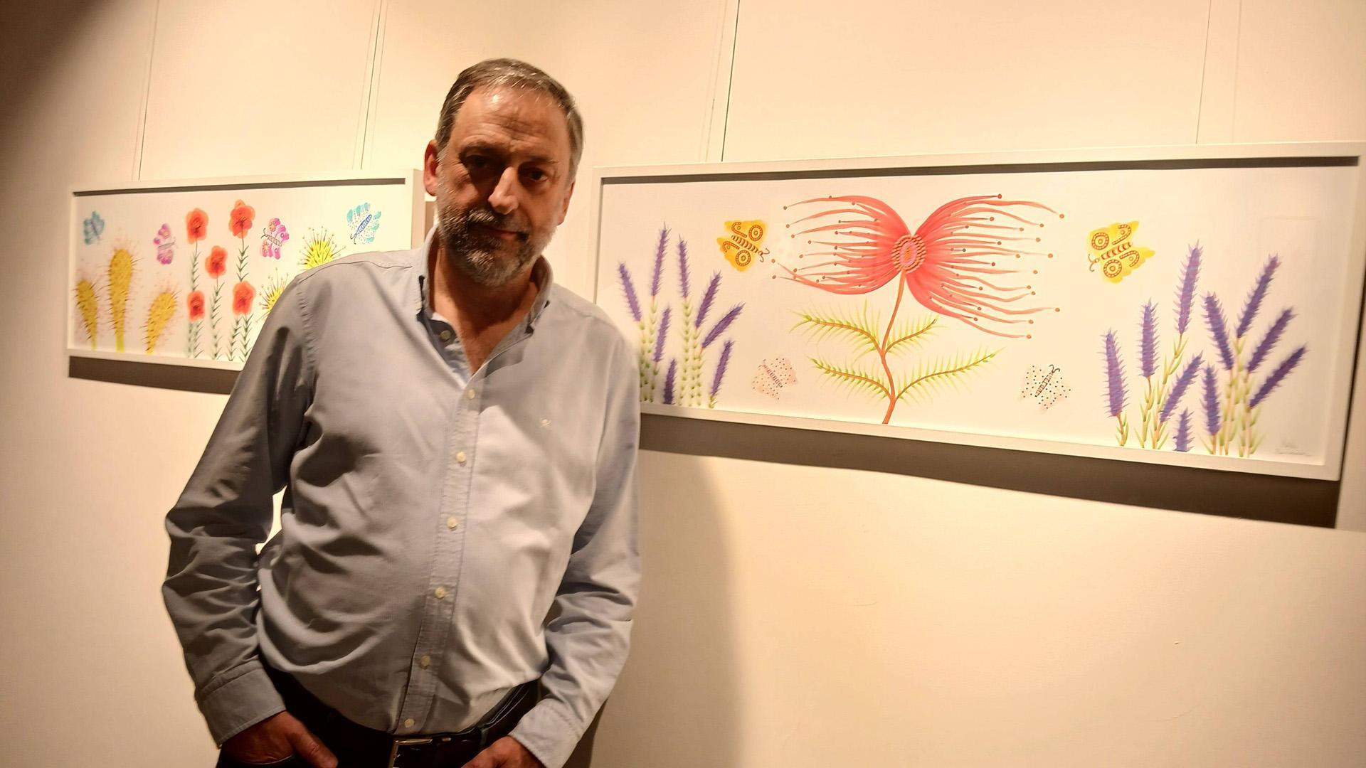 El artista navarro Nacho Barberena posa delante de sus cuadros con flores muy bellas que intentan atraer a las mariposas... a la muerte