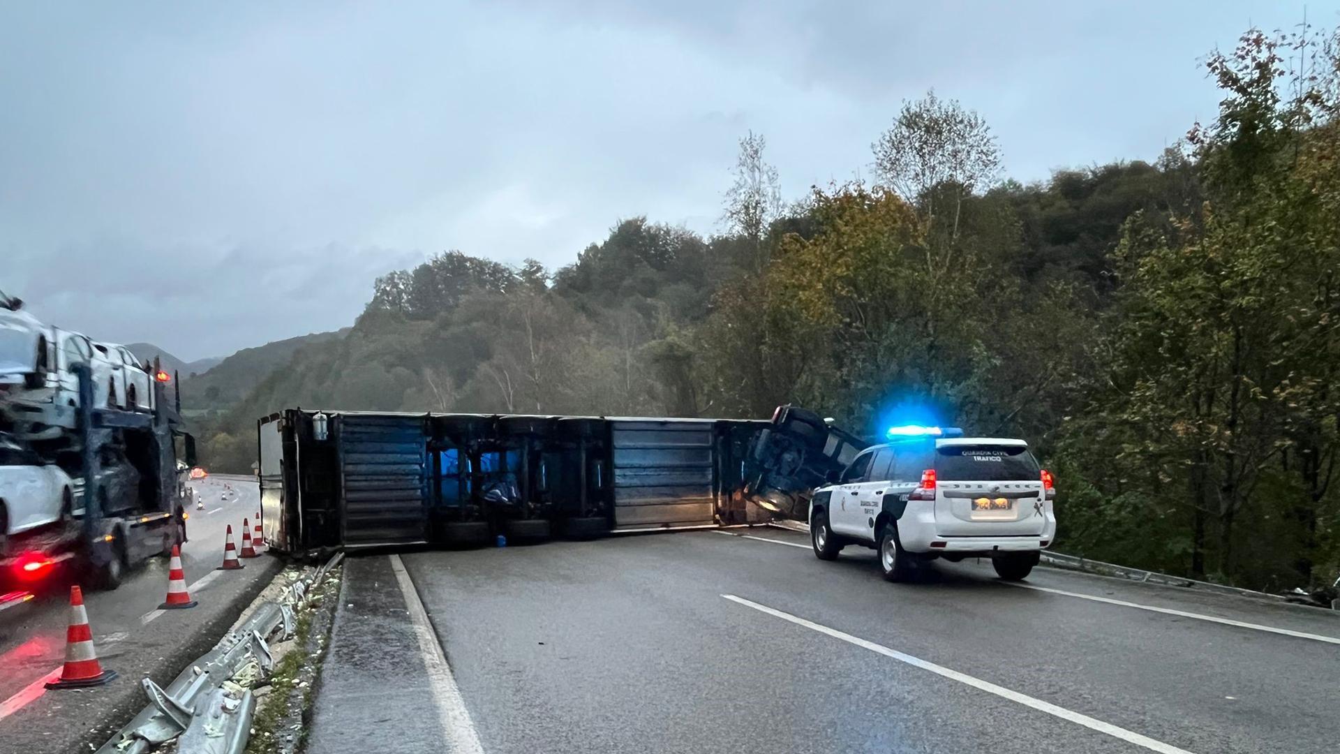 El camión accidentado, volcado sobre la vía