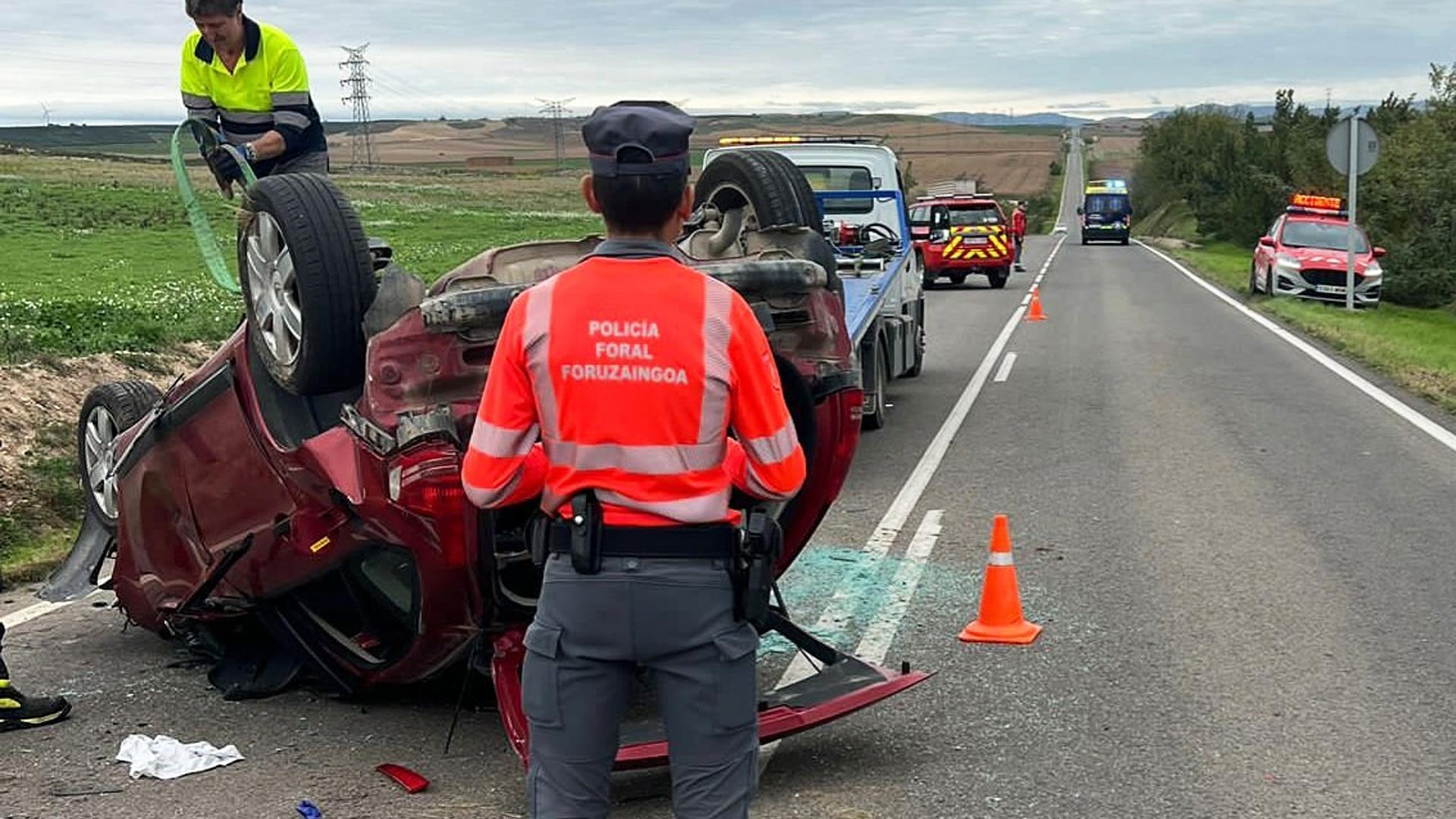 Un agente de la Policía Foral junto al automóvil accidentado en la NA-115 en Peralta