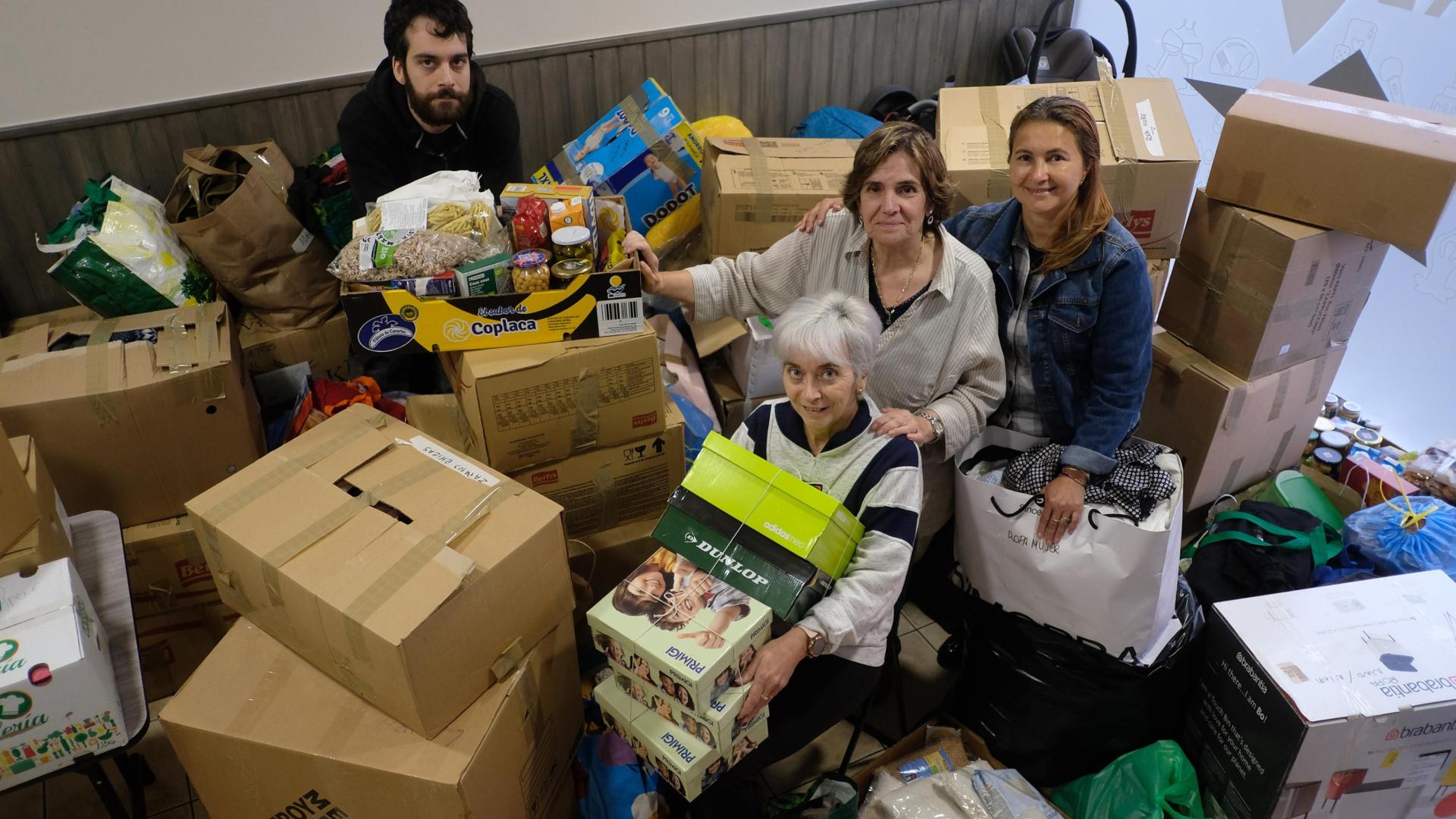 Vilma Silva,  Ana Bello (sentada), su hijo Asier Ortega y Montserrat Port posan con parte de la mercancía donada por los vecinos y vecinas de Zizur Mayor para la asociación Apoyo Mutuo.