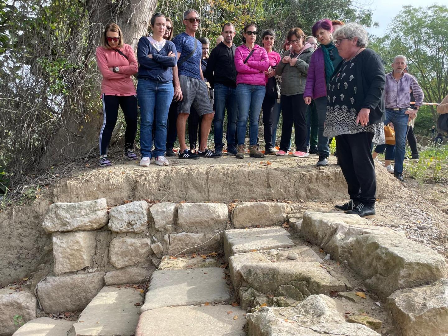 Charo Mateo ante las escaleras hechas con dinteles de la ermita ante el río Moliner.