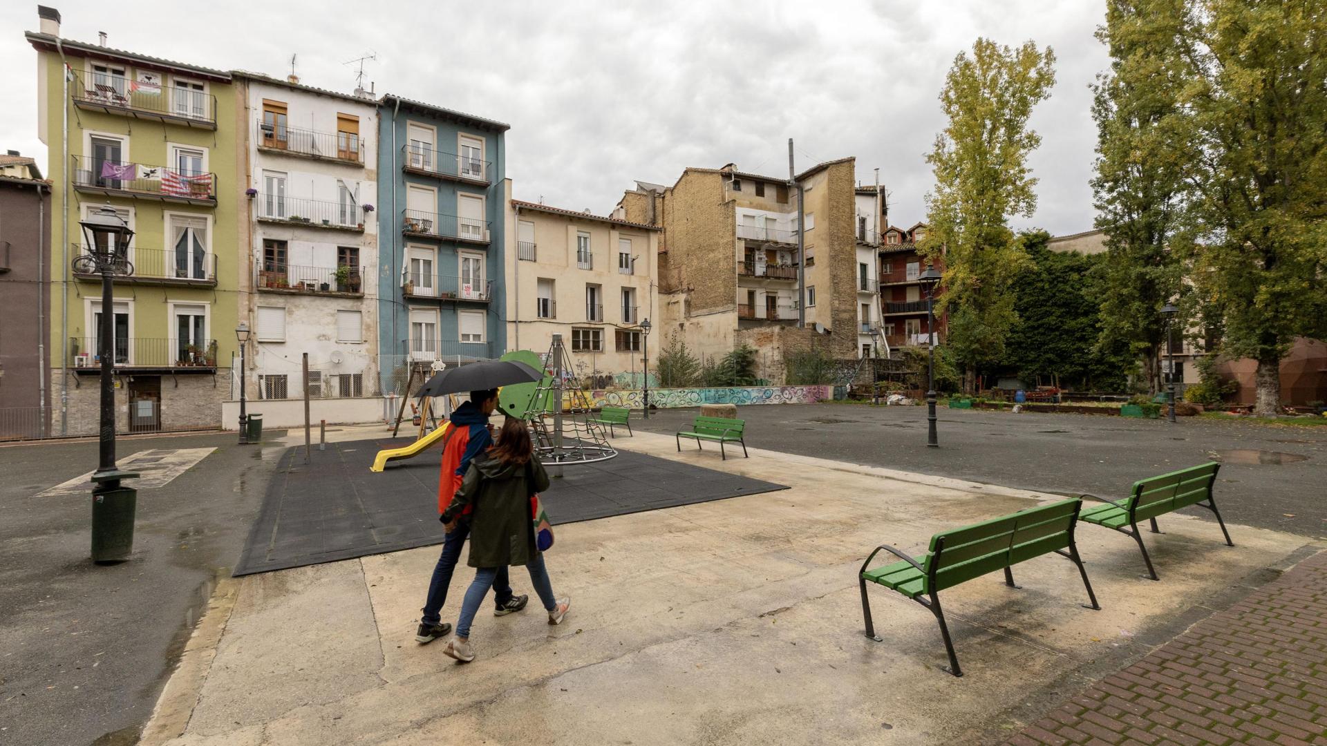 Una pareja atraviesa la plaza de Santa Ana de Pamplona en un día lluvioso