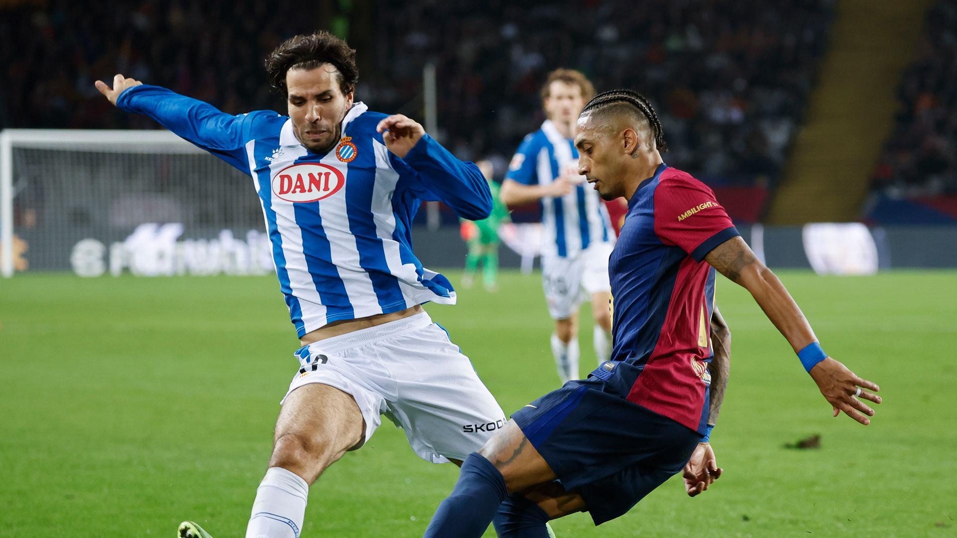 El atacante del FC Barcelona Raphinha (d), en acción durante el partido de LaLiga que enfrenta al FC Barcelona contra el Espanyol