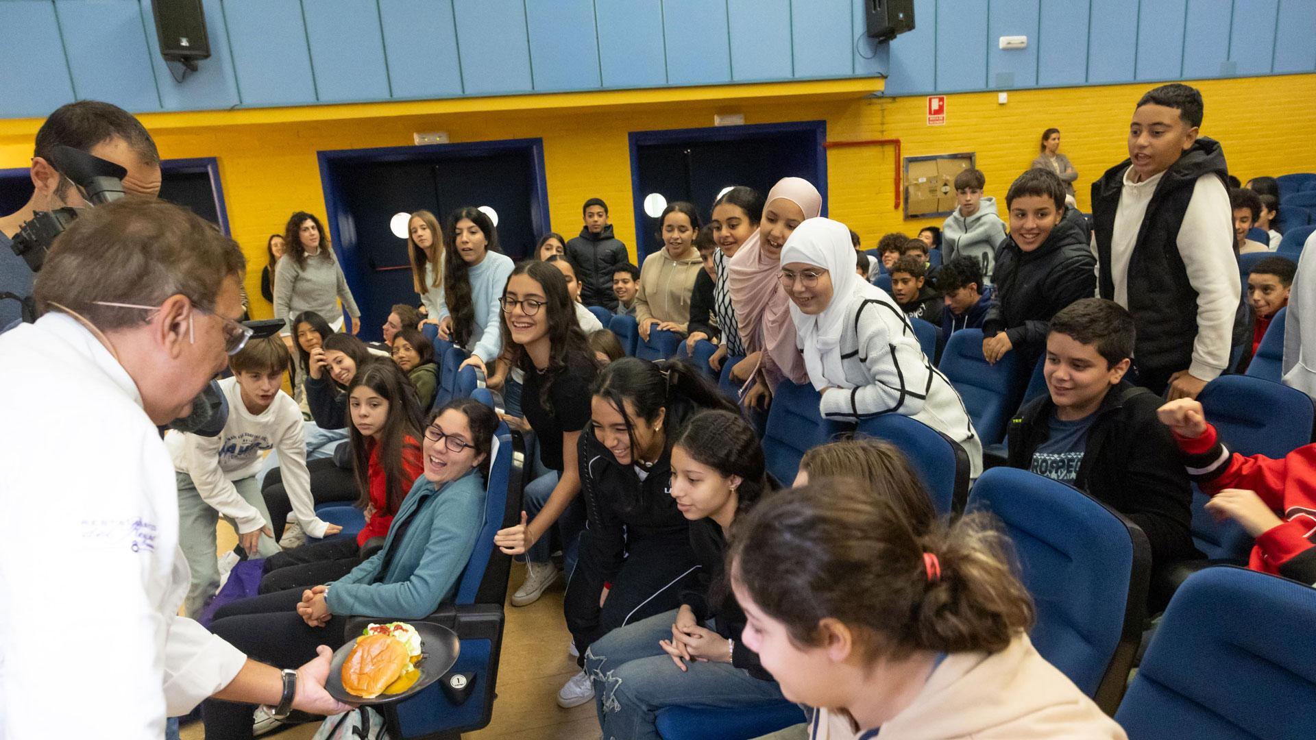 El chef Ricardo Gil Gil muestra a los alumnos del IES Benjamín de Tudela uno de los almuerzos saludables que preparó ayer en el centro.