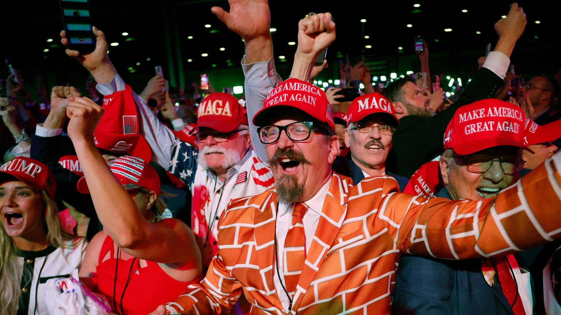 Seguidores de Donald Trump celebran la victoria del expresidente durante la noche electoral, uno de ellos viste un traje alusivo al muro que empezó a construir en la frontera.