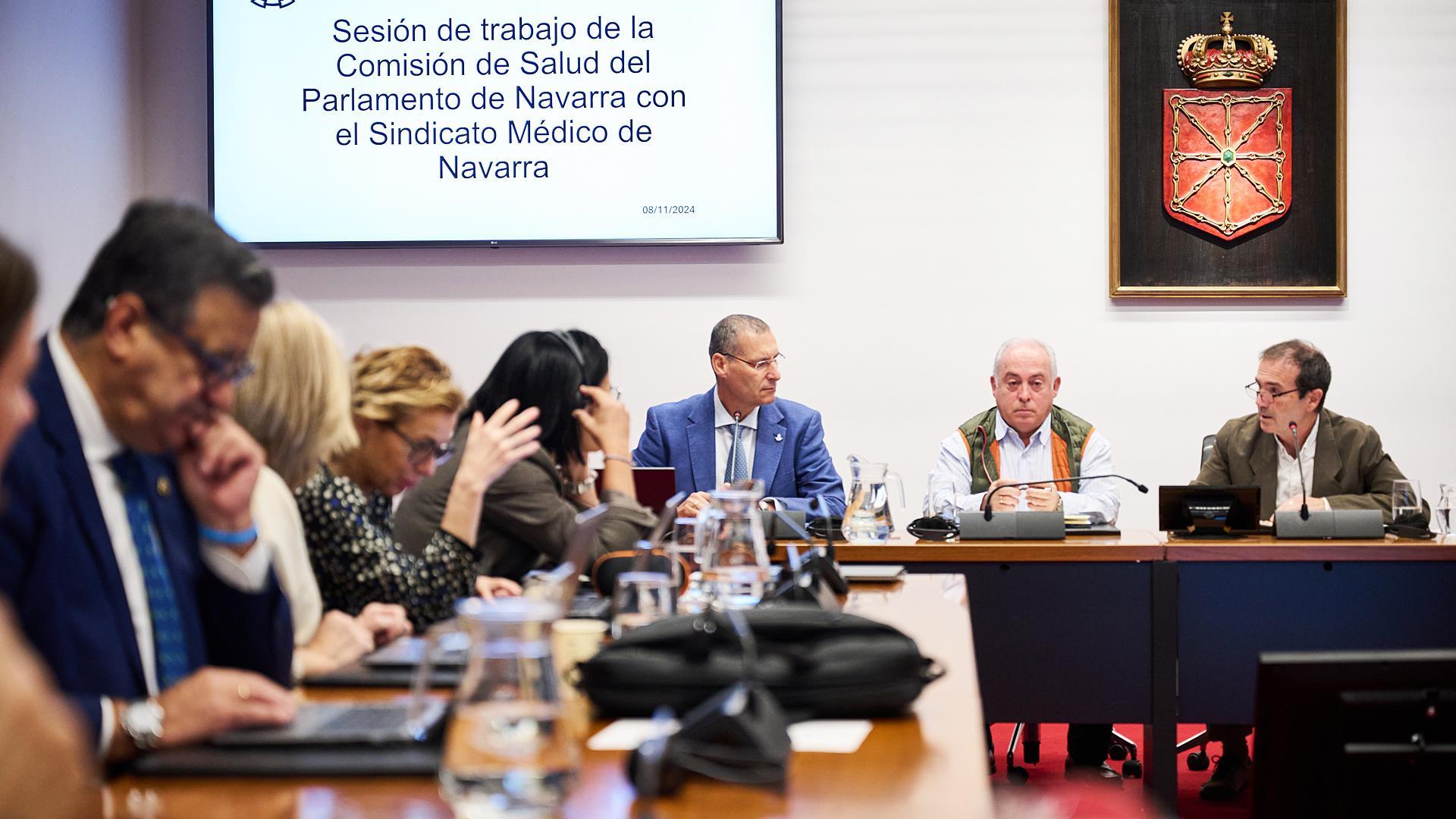 Al fondo, Alberto Pérez, Jesús Soria y Juan Ramón Sanchiz, representantes del Sindicato Médico de Navarra, durante la sesión en el grupo del Parlamento de Navarra /