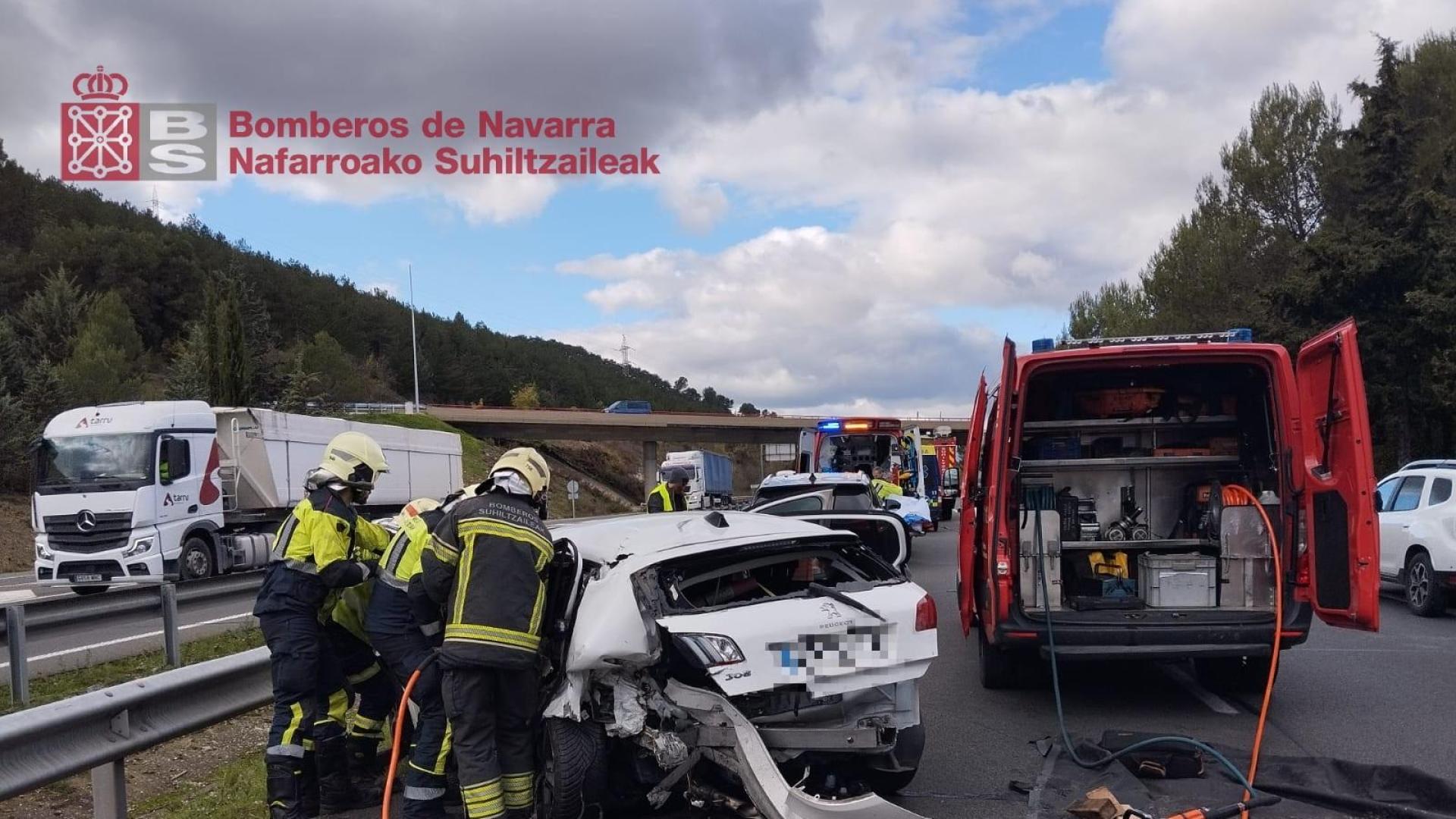 Efectivos de bomberos, junto a un vehículo implicado en el siniestro