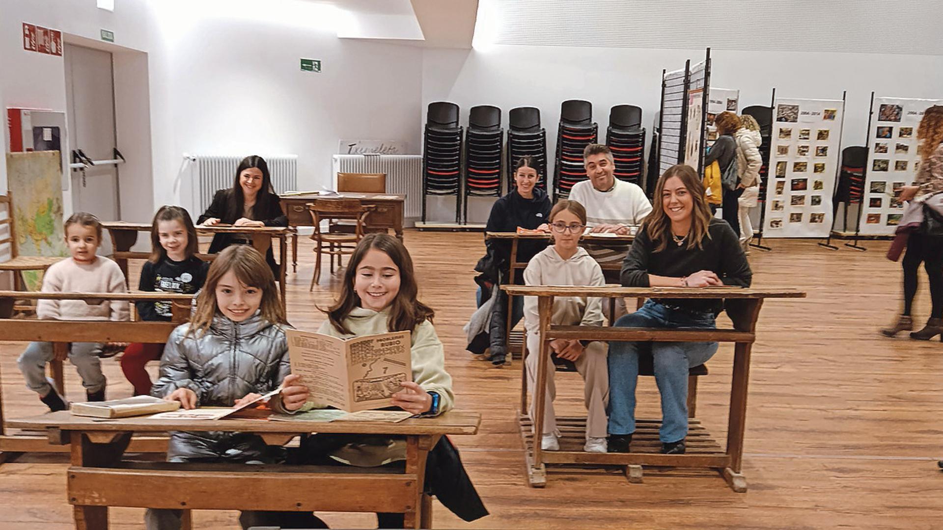 Profesoras, ex alumnos y ex alumnas y alumnas actuales del centro en el aula antigua que se recreó