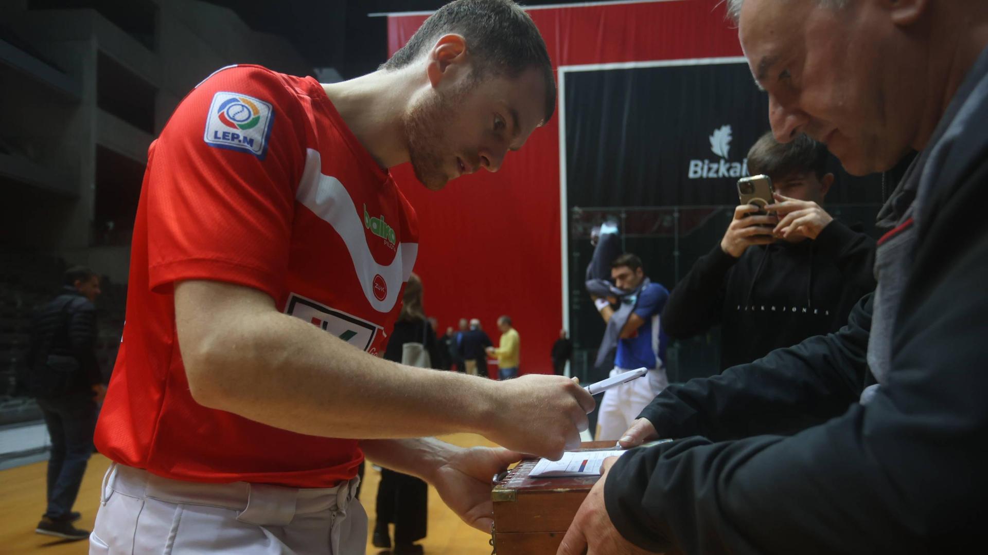 Unai Laso firma en la caja de pelotas de la final.