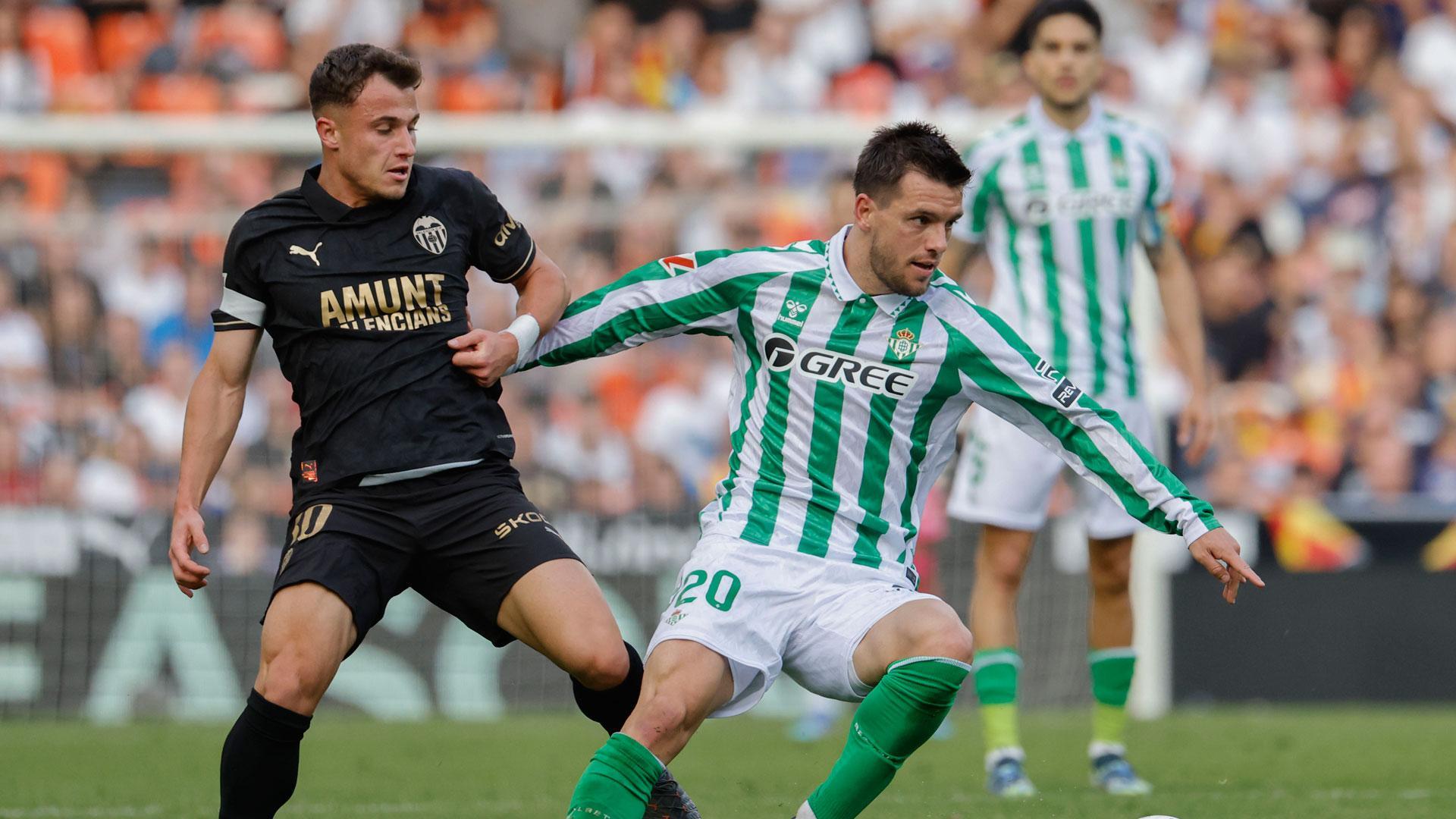 Giovani Lo Celso del Betis lucha por el balón con German Valera del Valencia durante el partido de la jornada 14 de LaLiga disputado este sábado en el estadio de Mestalla