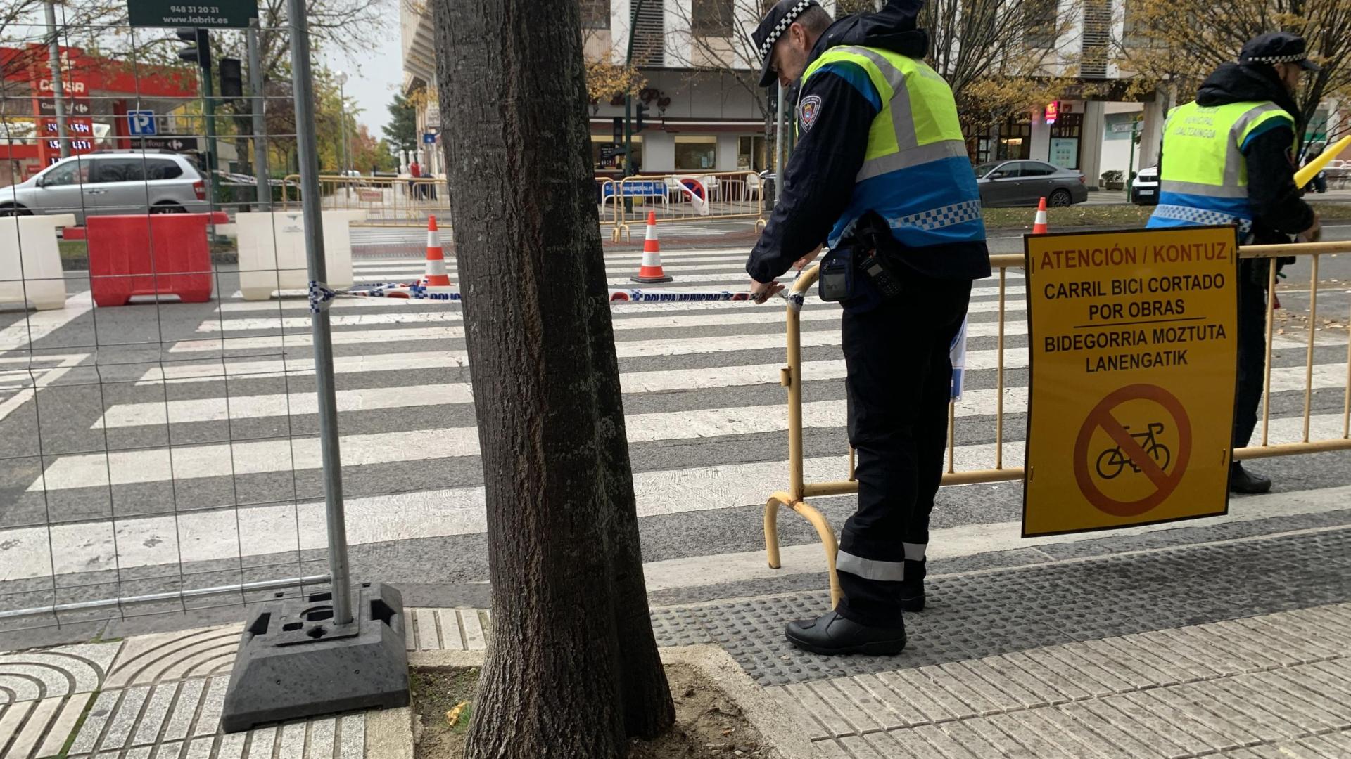 Dos agentes de Policía Municipal colocan cintas para evitar que peatones se cuelen por el paso de cebra anulado en Pío XII