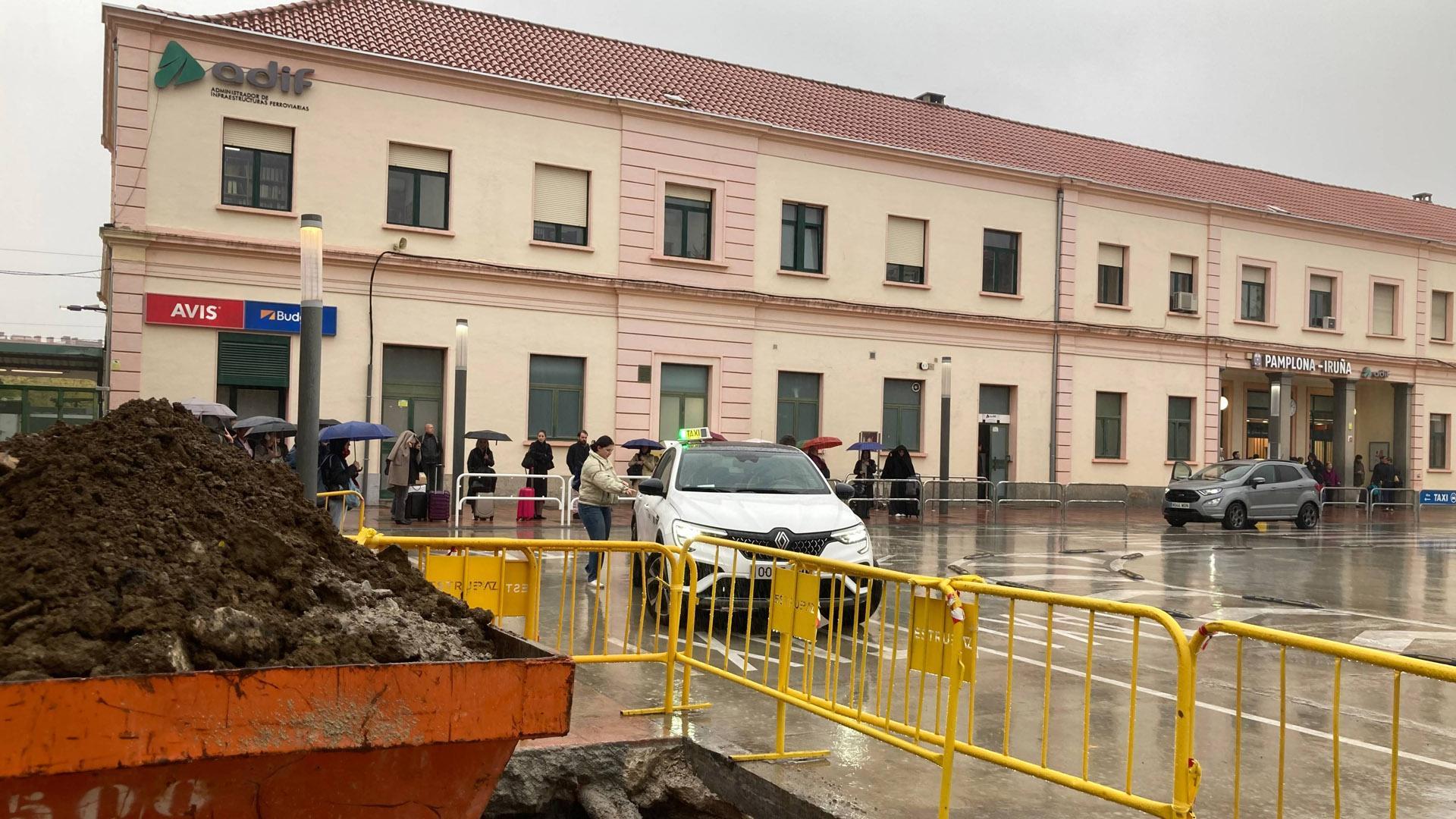 En primer plano, las obras preparatorias de la marquesina. Detrás, pasajeros bajo la lluvia