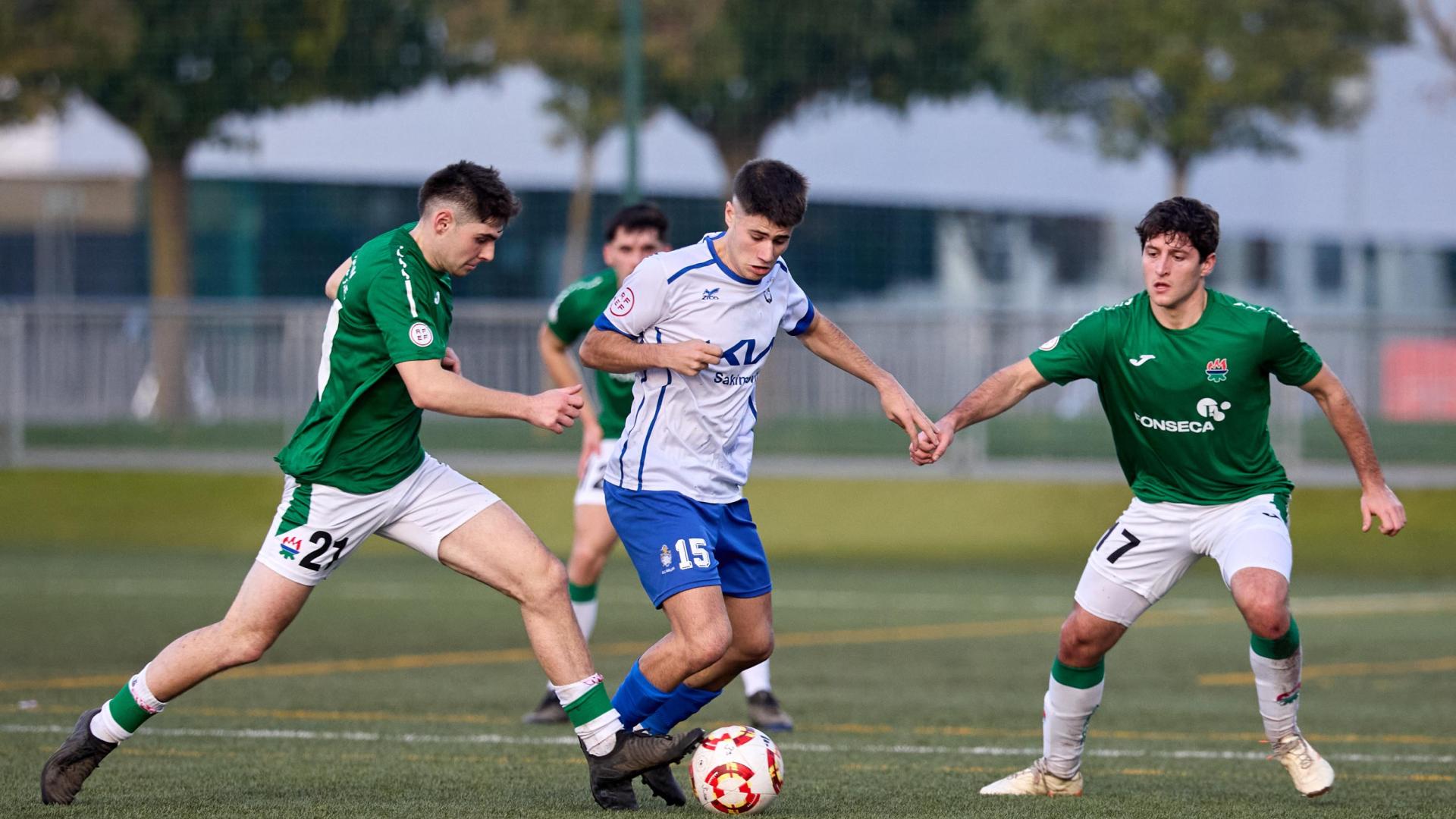 Xabi Goñi y Asier Galeano, del San Juan, tratan de robarle el balón a Gaizka Tollar, del Burladés