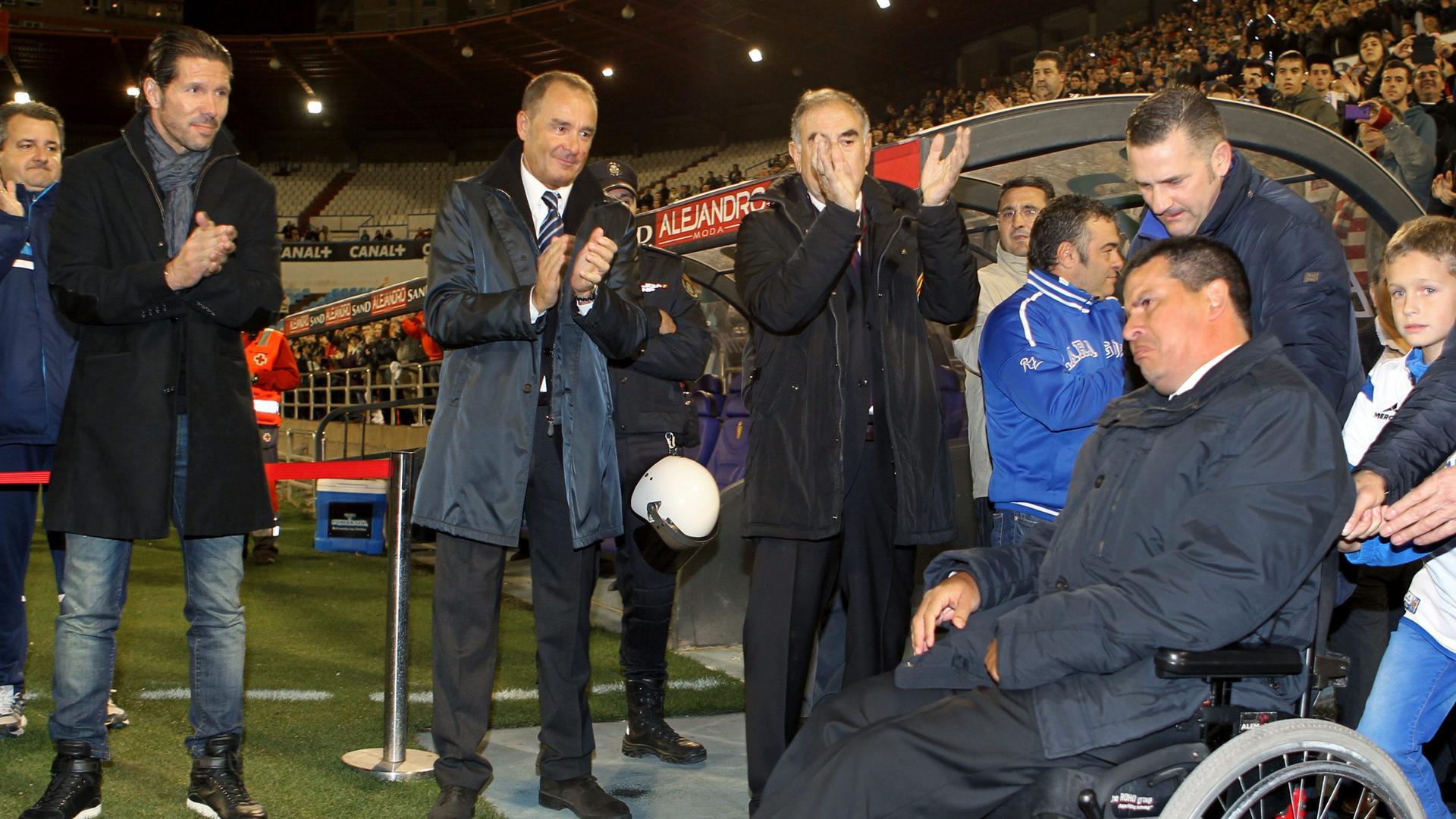 El entrenador del Atlético de Madrid, el argentino Diego Simeone (i) y el técnico que ganó la Recopa con el Real Zaragoza, Víctor Fernández (2i), reciben al exjugador argentino del Zaragoza Fernándo Cáceres (d), a su salida al césped del estadio de La Romareda