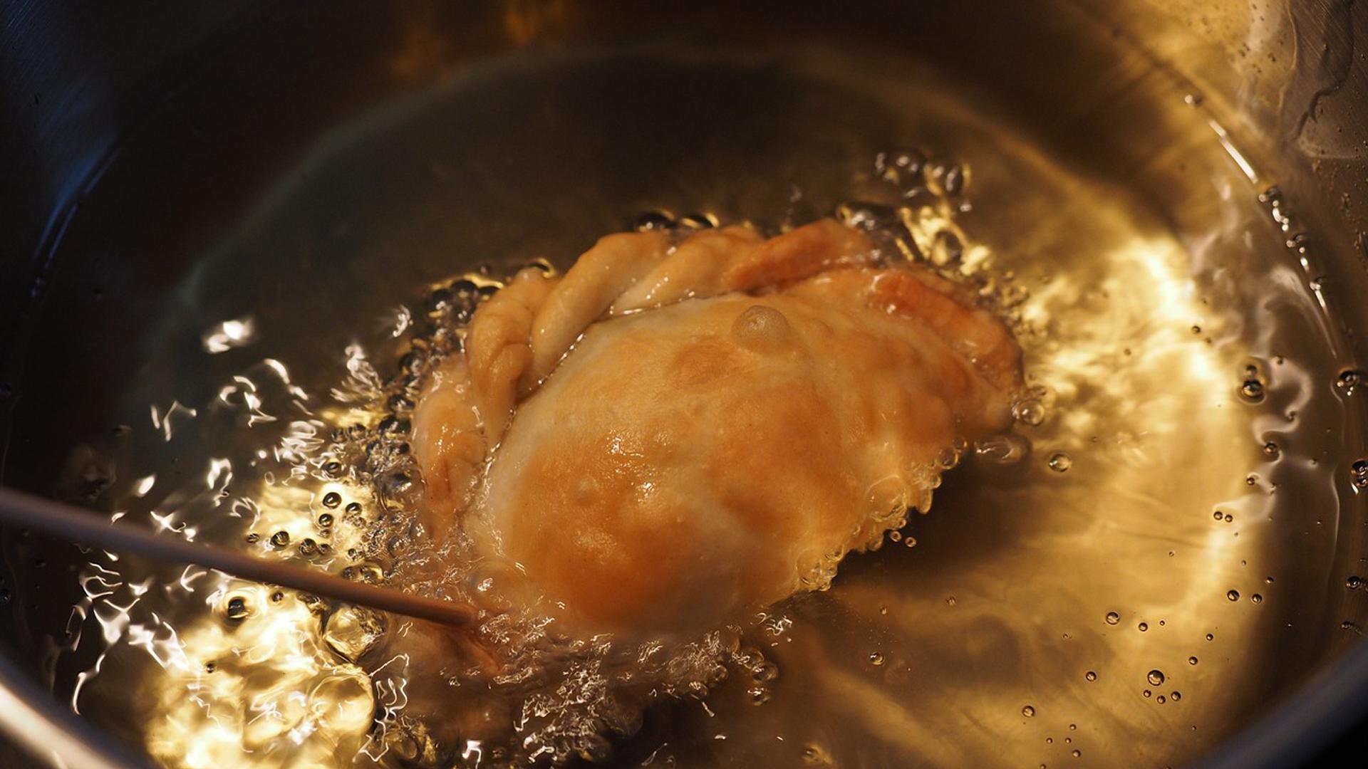 Una persona fríe una empanada