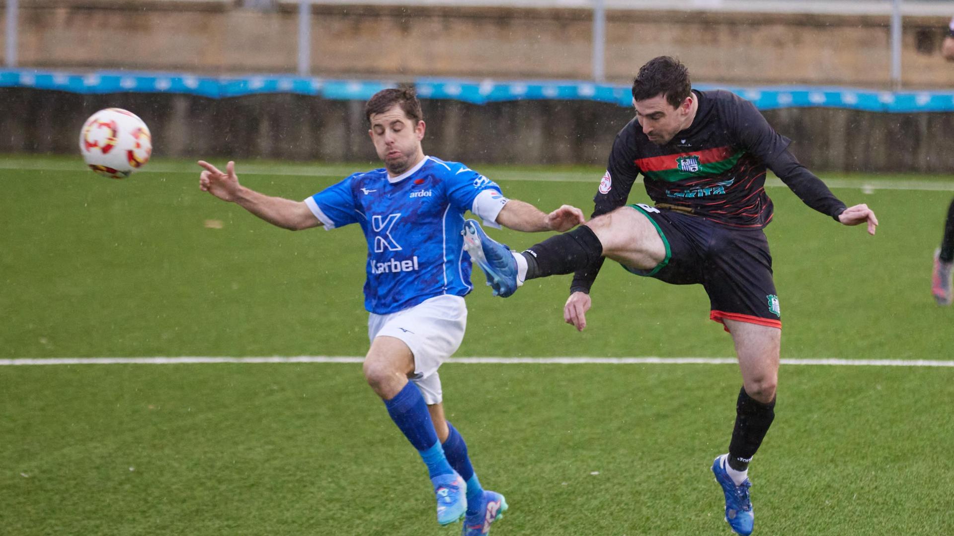 Álvaro Arizcuren, capitán y goleador del Ardoi, presiona a Enrique Burgui, jugador del Beti Kozkor