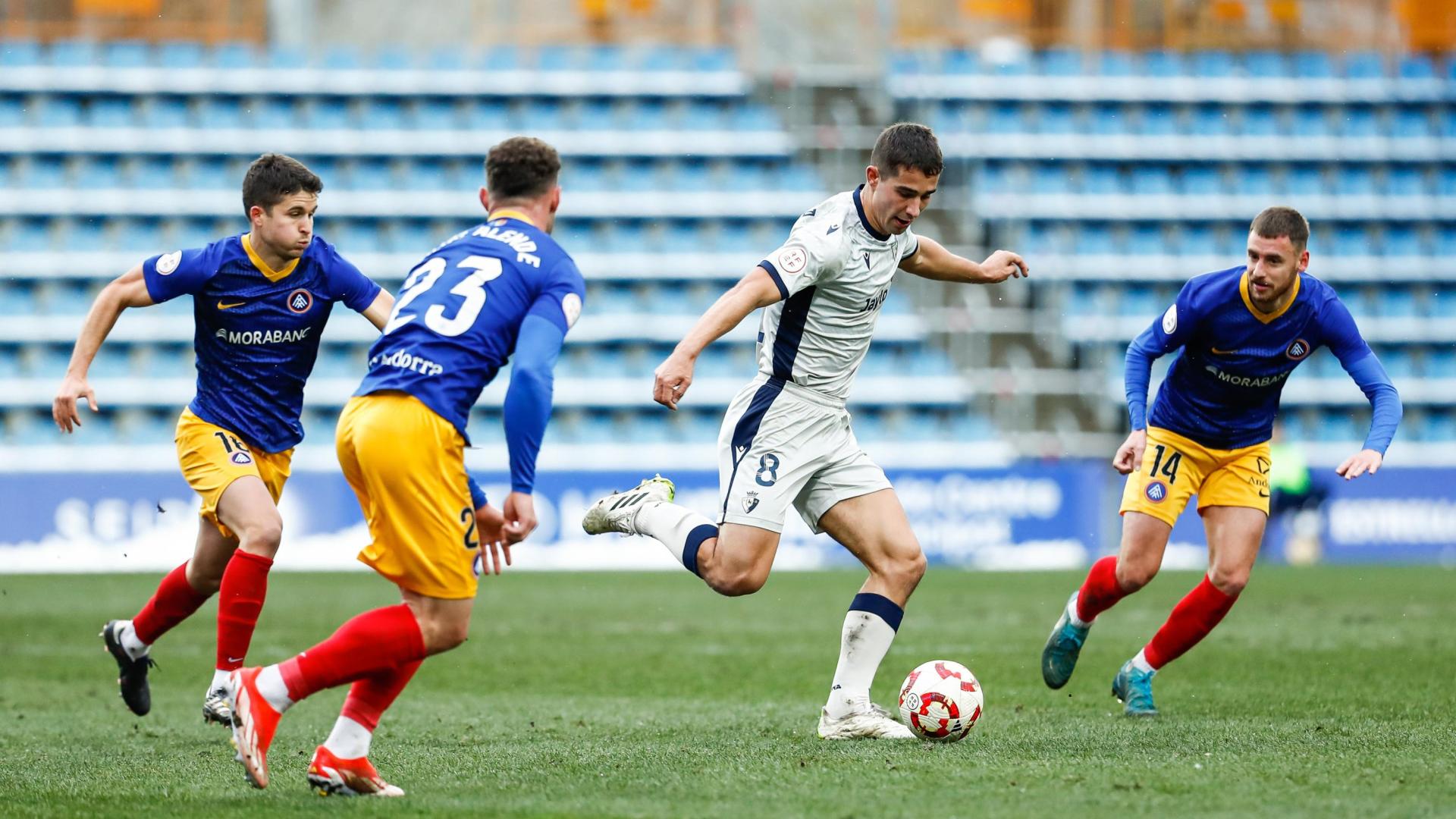 El centrocampista de Osasuna Promesas Asier Osambela, a punto de realizar un pase ante Sergio Molina, Diego Alende y Álvaro Peña, del Andorra