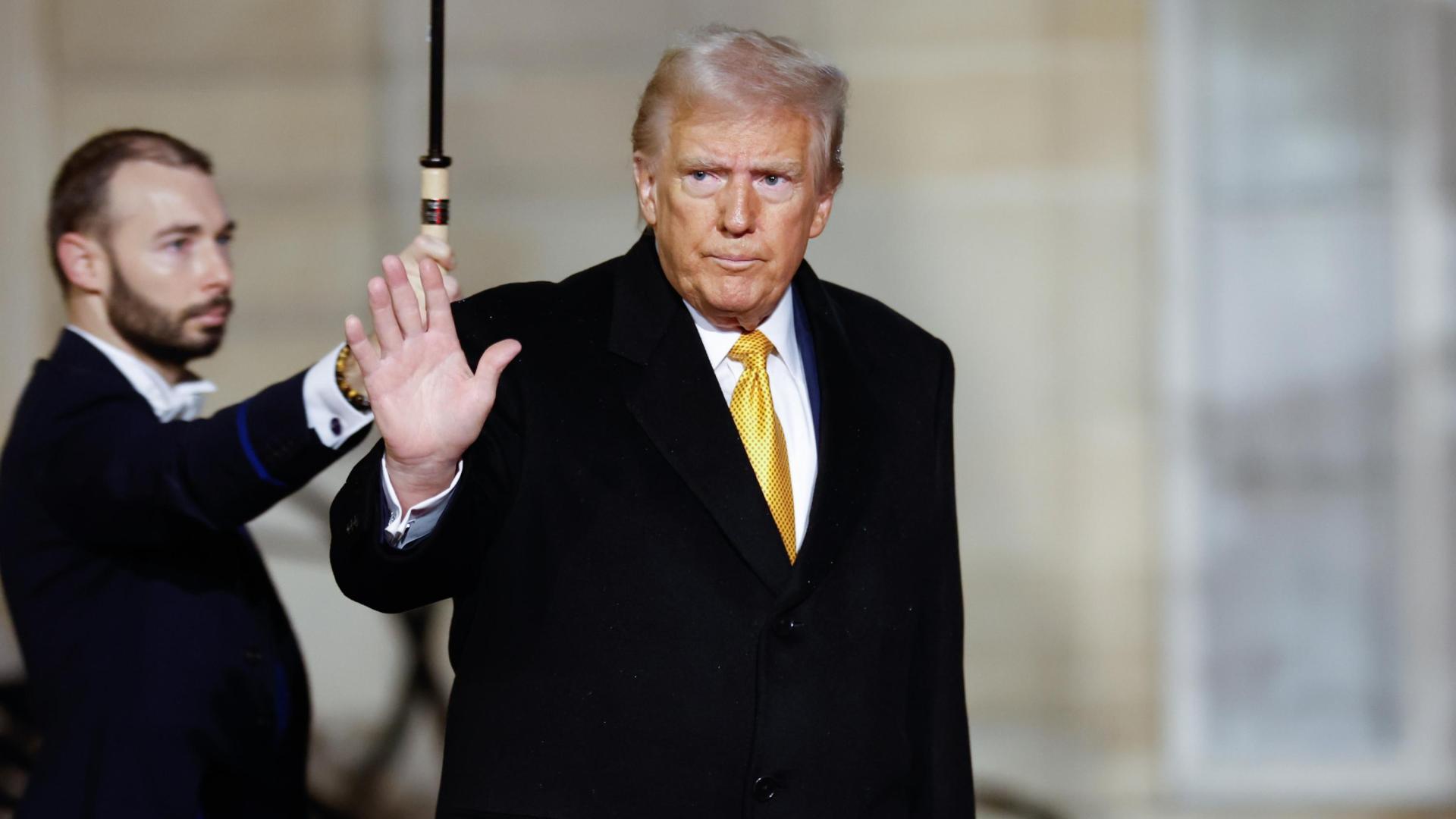 El presidente electo de Estados Unidos, Donald Trump, saluda este sábado a su salida del Palacio del Elíseo en París
