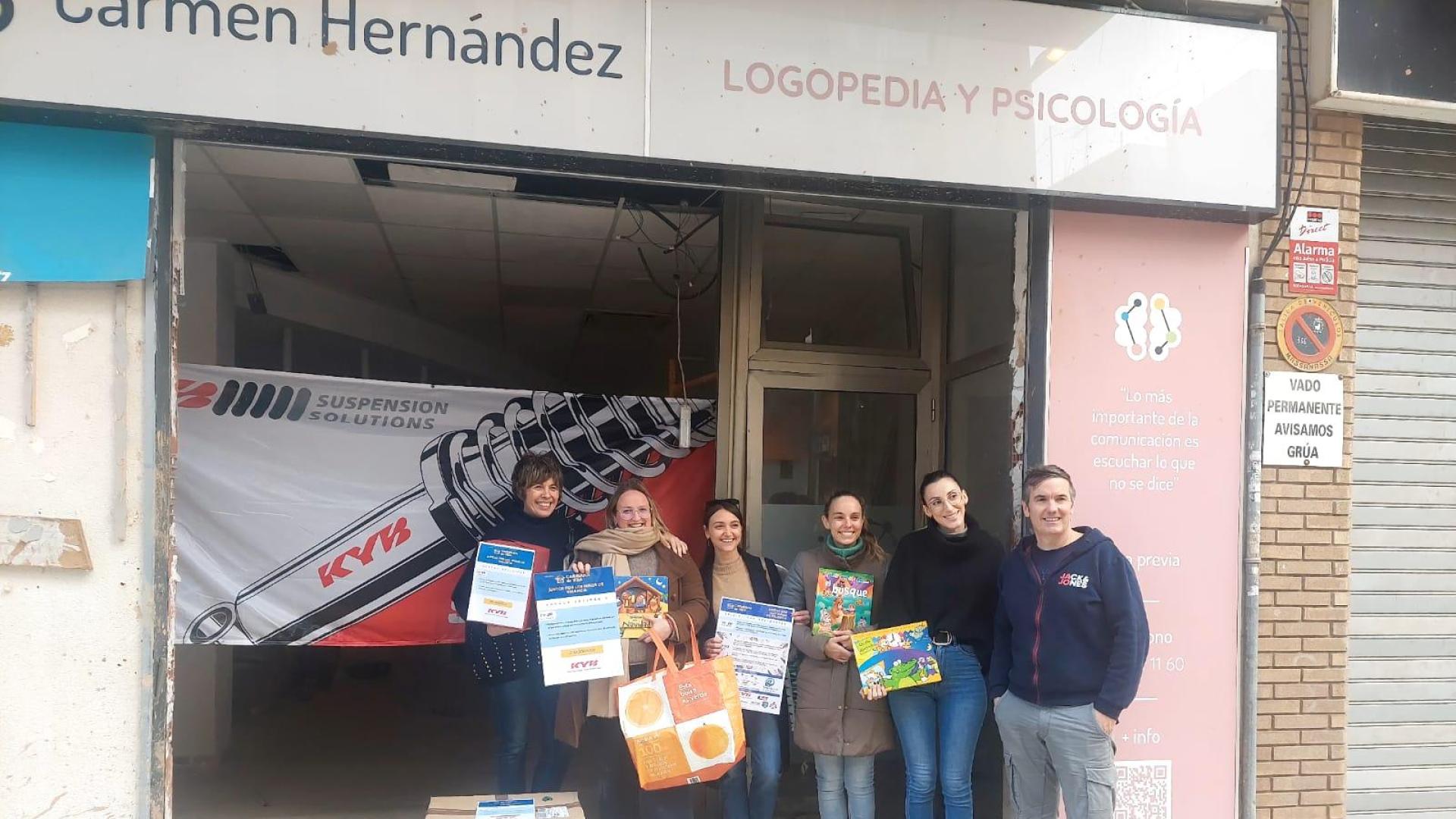 Representantes de Caravana de Vida y trabajadores del Centro de Psicopedagogía Carmen Hernández, espacio afectado por las inundaciones, con el material entregado