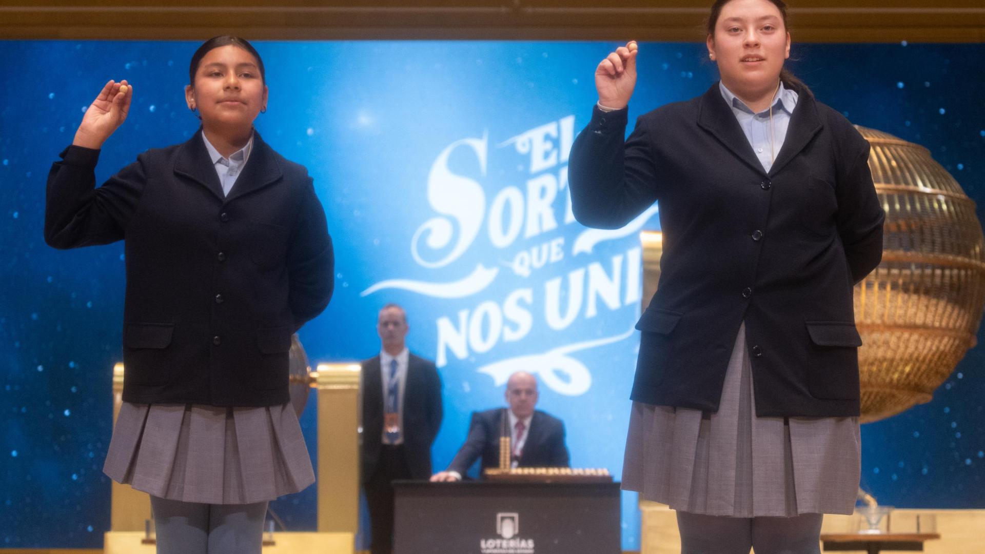 Yadira Quinde Mendoza (i) y Kiara Román Benítez (d), cantan un quinto premio, el número 45.225 durante la celebración del Sorteo Extraordinario de la Lotería de Navidad 2024