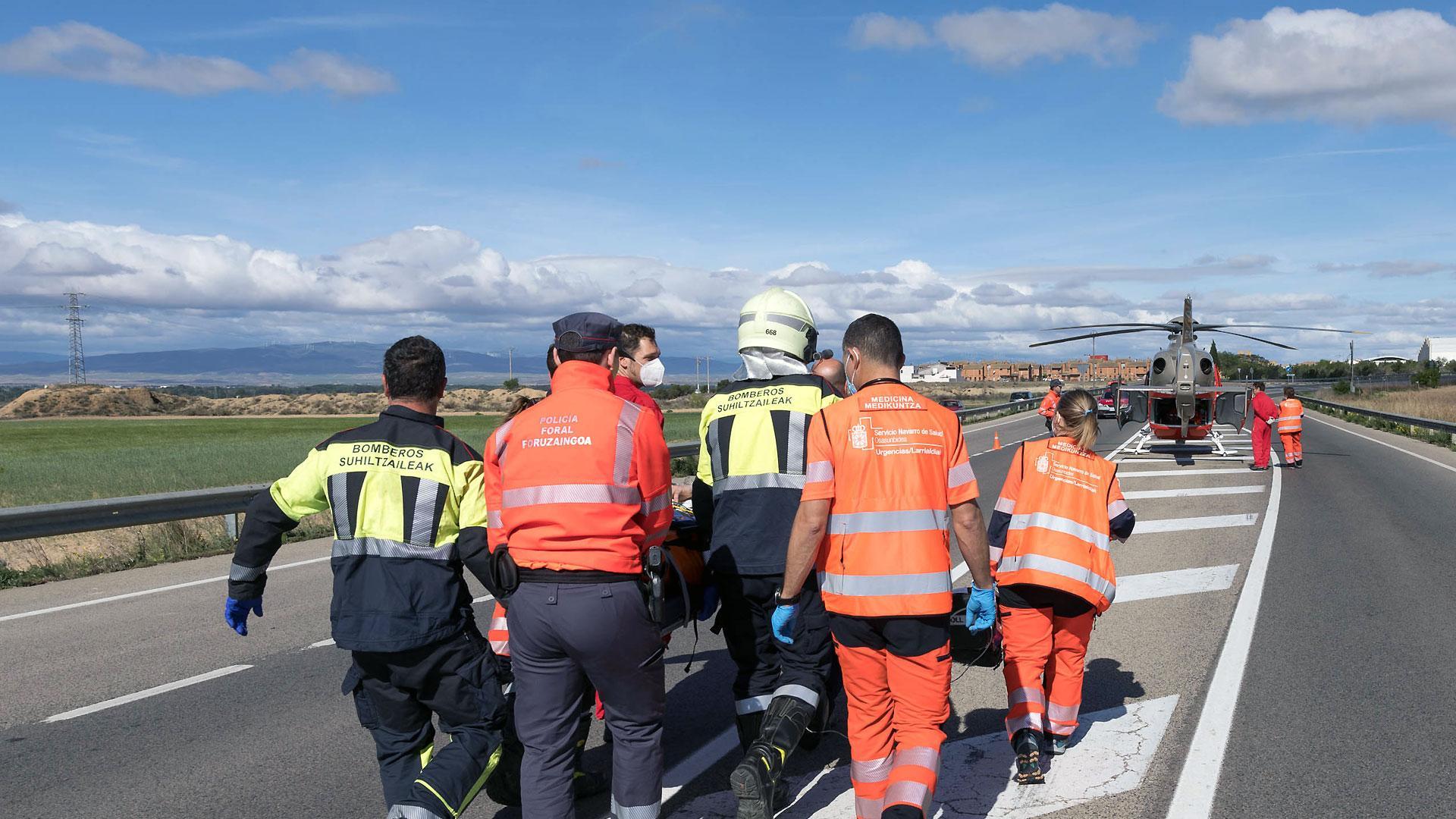Bomberos, agentes de Policía Foral y sanitarios trasladan a un herido a un helicóptero