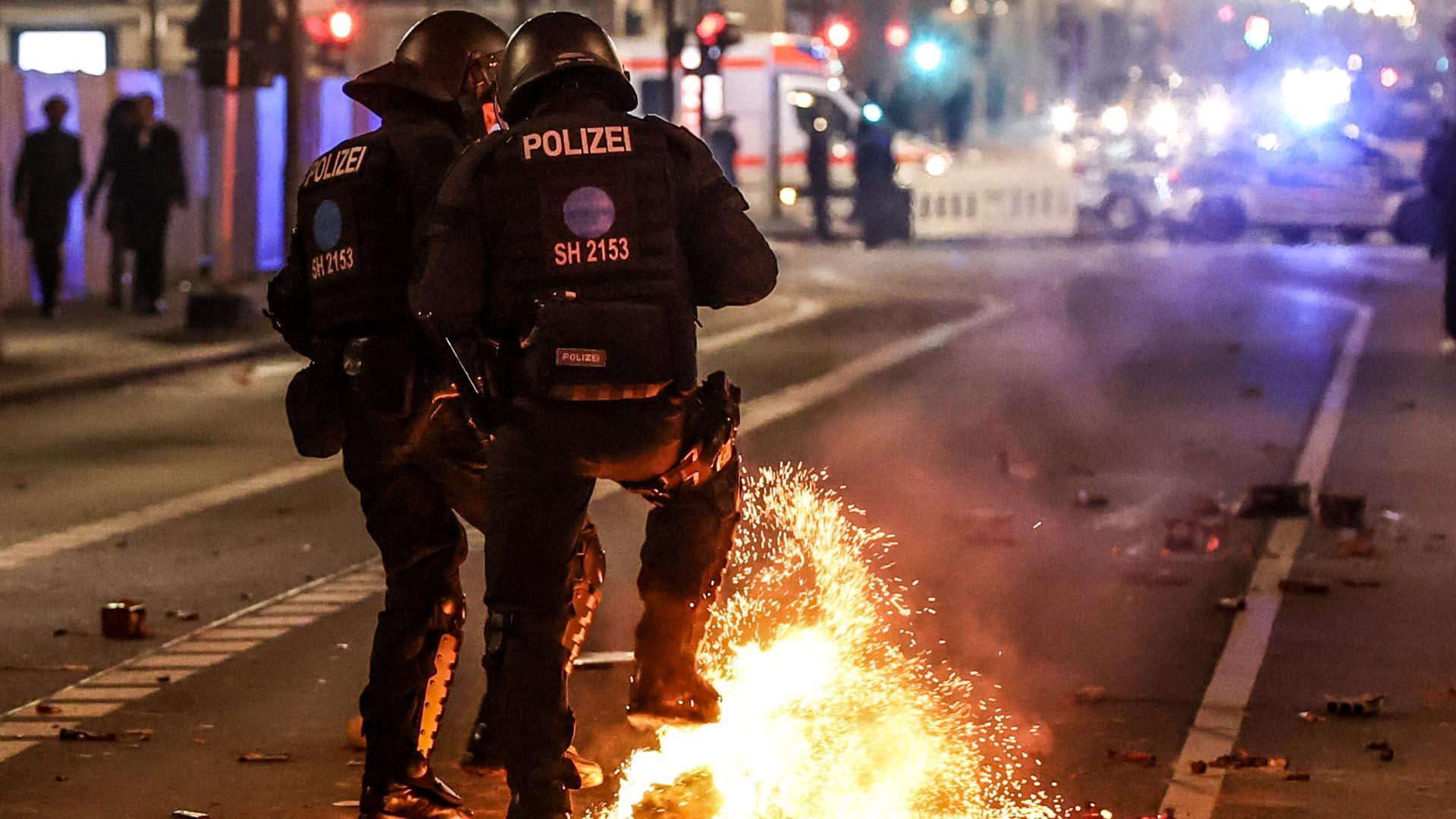 Policías antidisturbios alemanes tratan de sofocar las llamas causadas por un aparato pirotécnico en las calles de Berlín la pasada Nochevieja