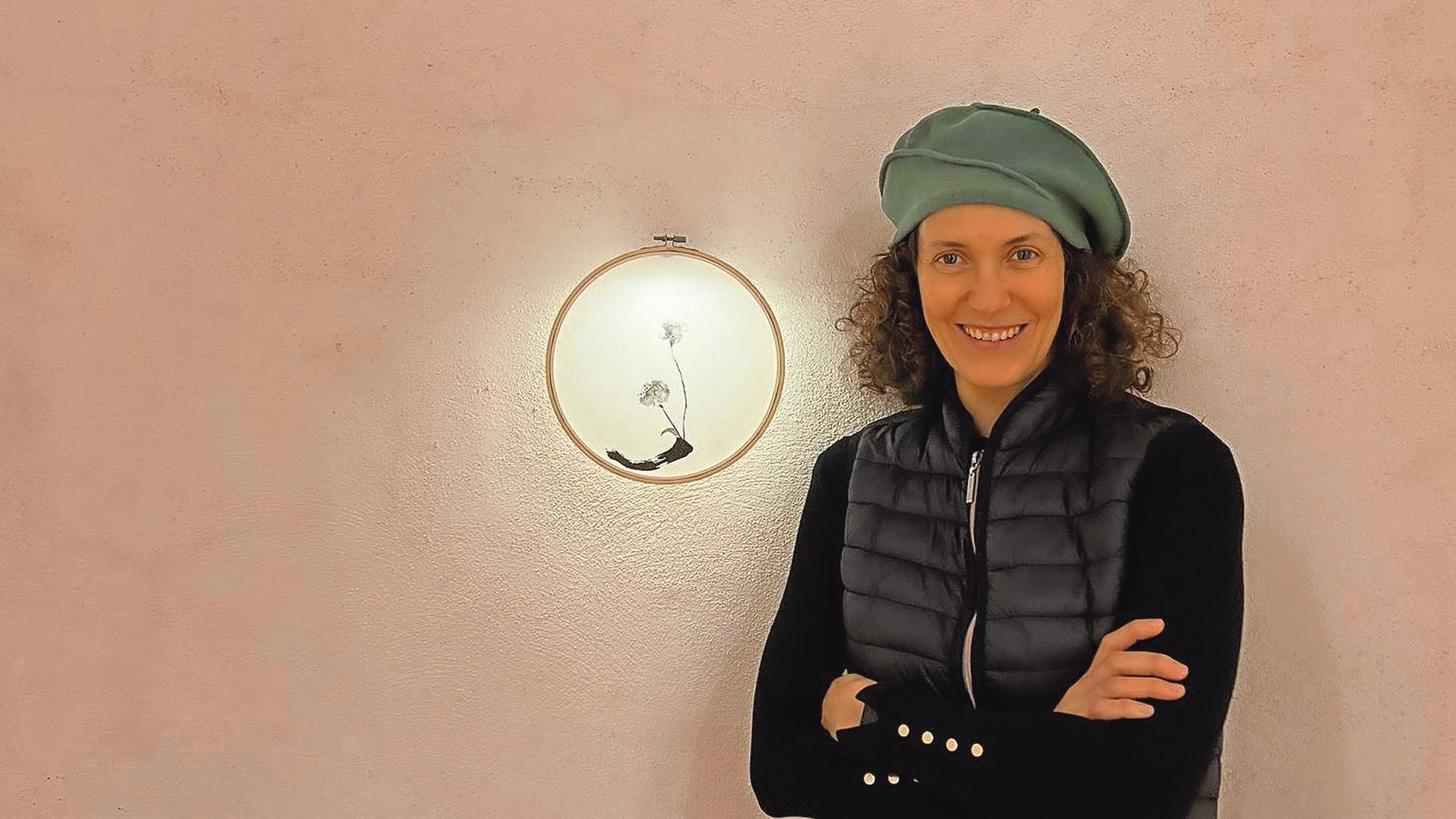La artista Naroa Armendáriz, en la expo. Detrás, una de las obras
