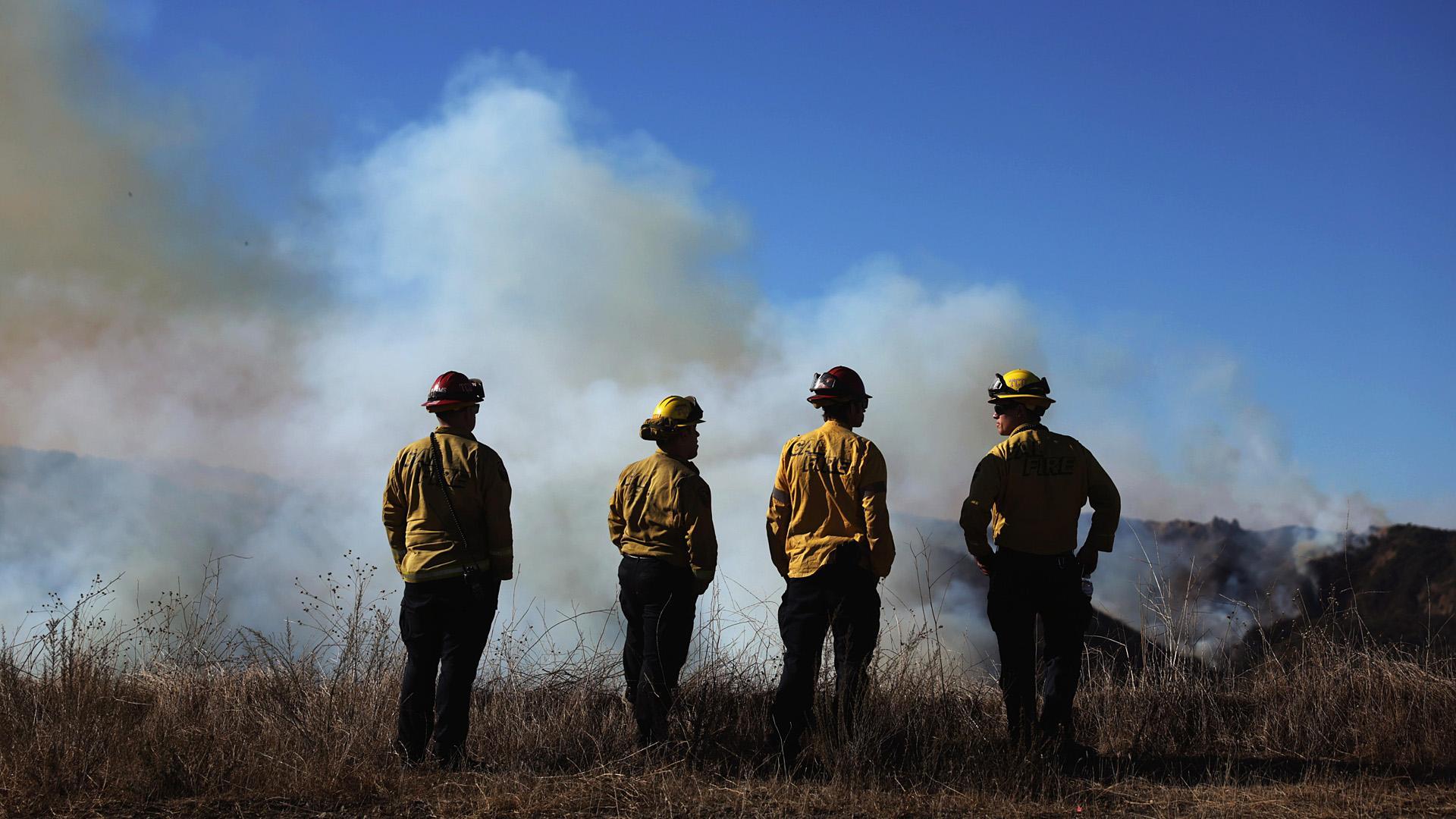 Cuatro bomberos observan desde una zona montañosa de Los Ángeles los estragos de las llamas /
