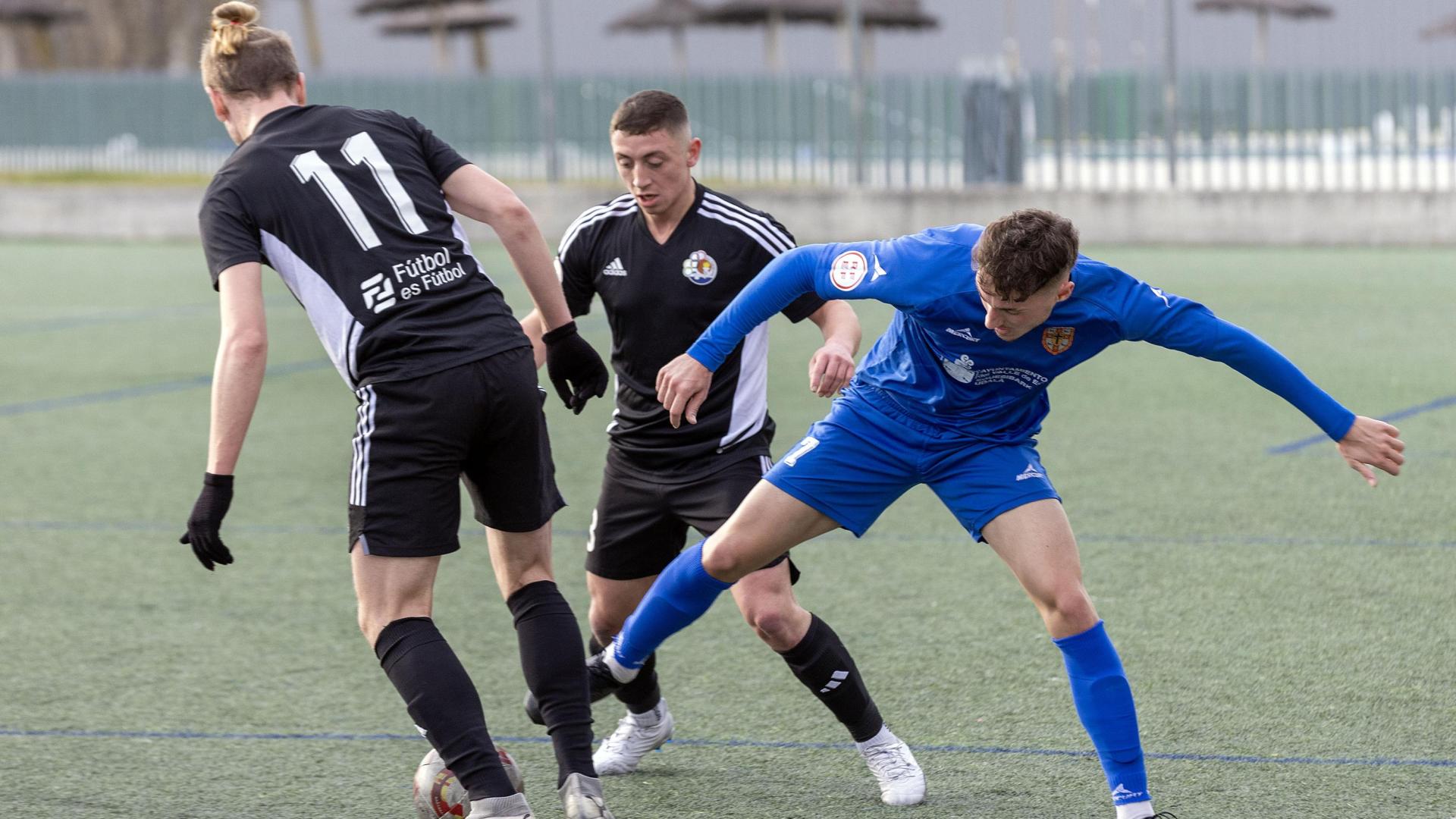 Eneko Oroz, del Valle de Egüés, busca robar el balón ante Elizalde y Oihan Goñi, del Txantrea