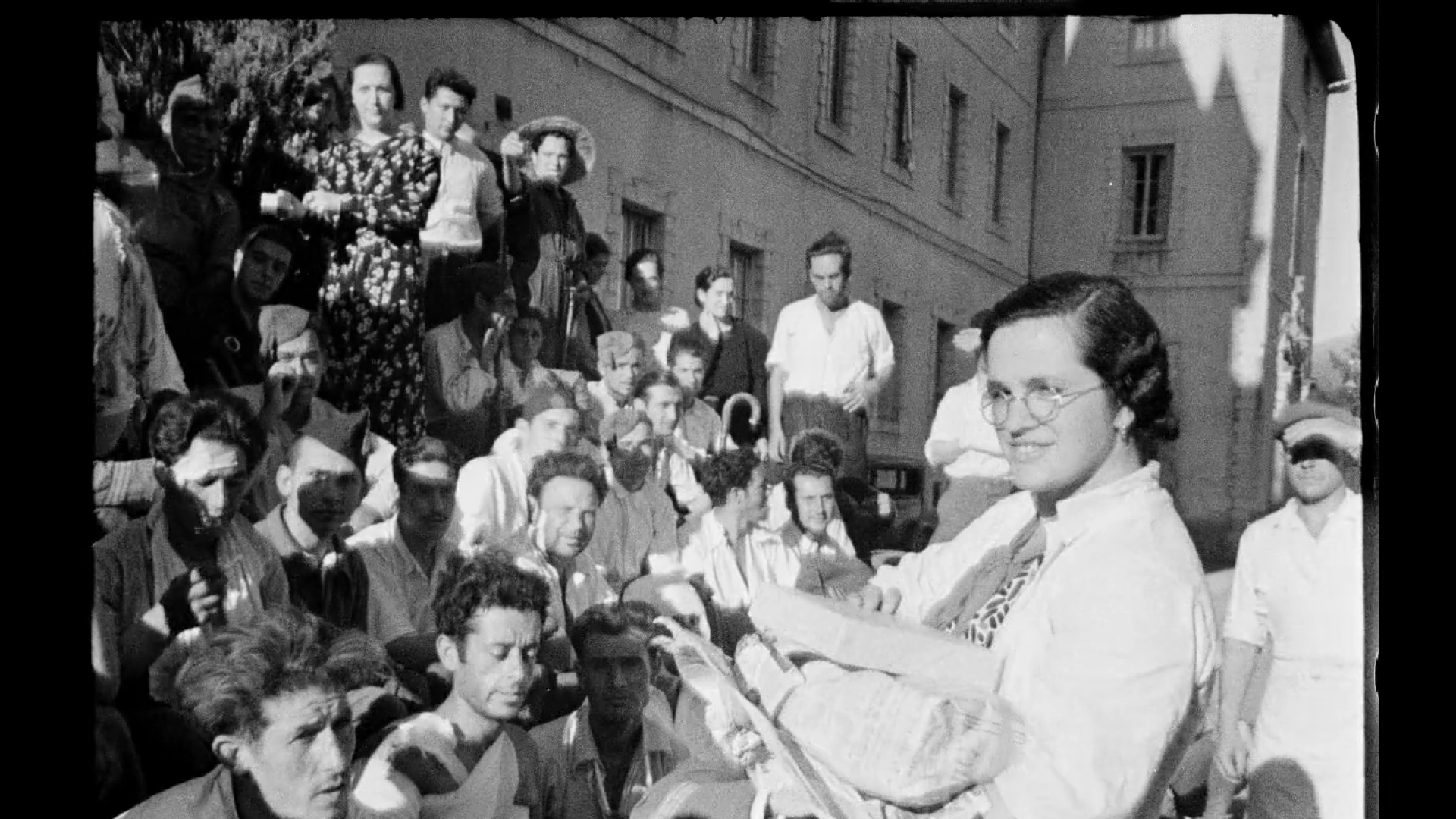 Una ‘margarita’ del Baztan reparte cajetillas de tabaco y dulces entre los heridos sentados en la escalinata de entrada del hospital de sangre de Lekaroz, en septiembre de 1936