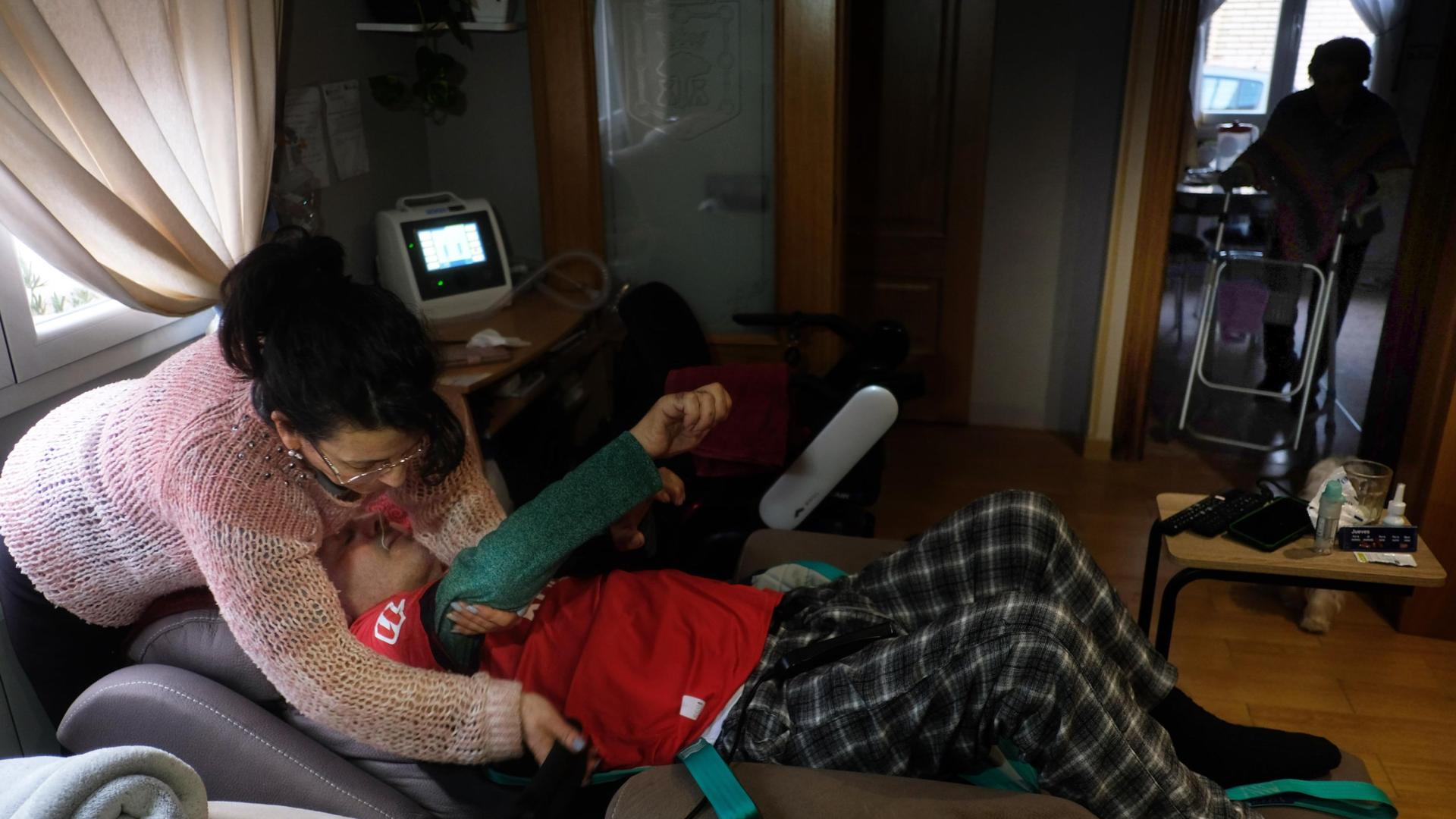 27 DE ENERO DE 2025. María García ajusta las cinchas para poder levantar del sillón a su marido.