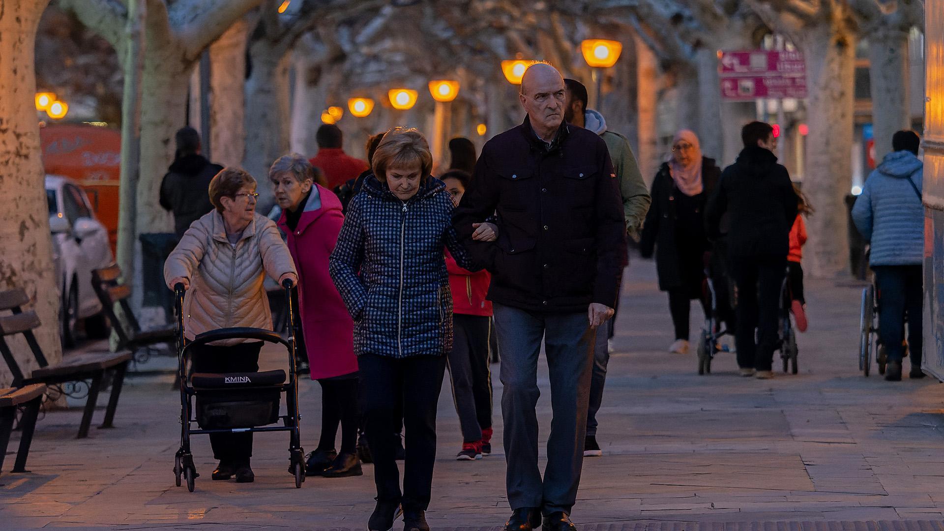 Varias personas pasean por el paseo del Padre Calatayud, en Tafalla /